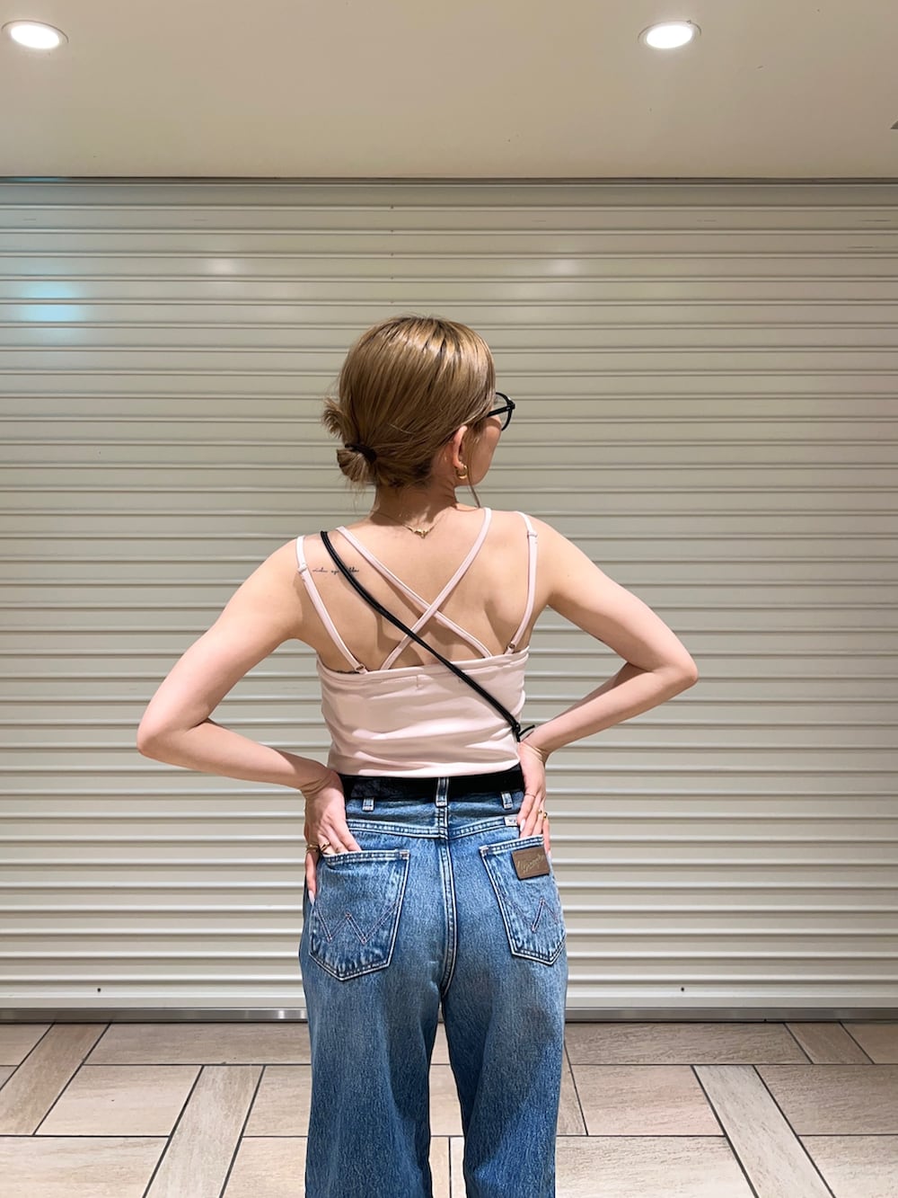 ピンク系のキャミソール、ブルー系のデニムパンツを着用したレディースの夏コーディネートの5枚目の写真