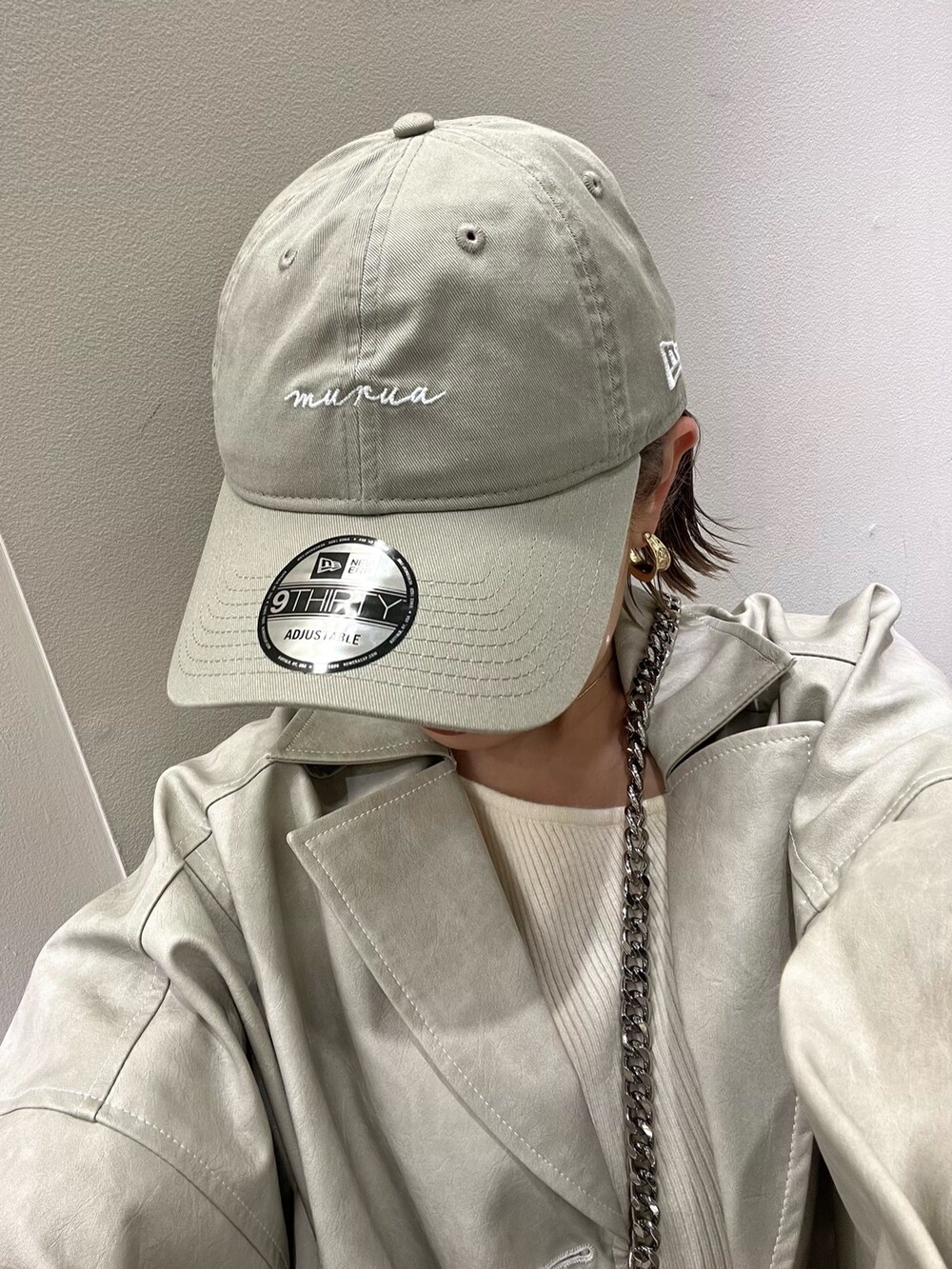 ホワイト系のブルゾン、ホワイト系のニット/セーター、ホワイト系のハンドバッグを着用したレディースの冬コーディネートの8枚目の写真