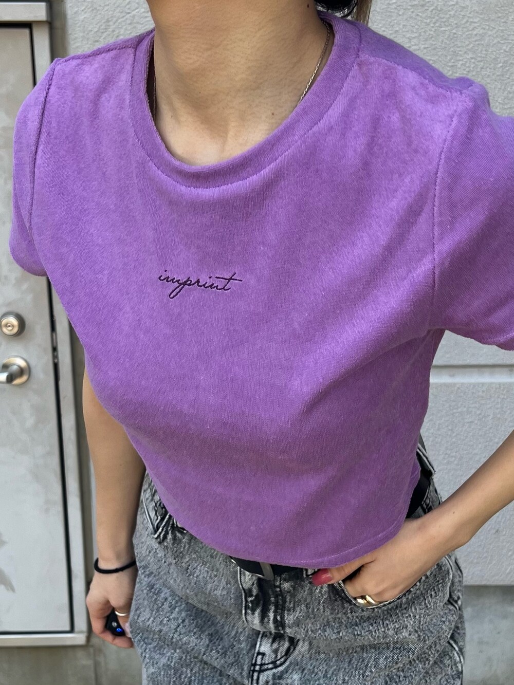 グレー系のデニムパンツ、パープル系のTシャツ/カットソー、ブラック系のベルトを着用したレディースの春コーディネートの7枚目の写真