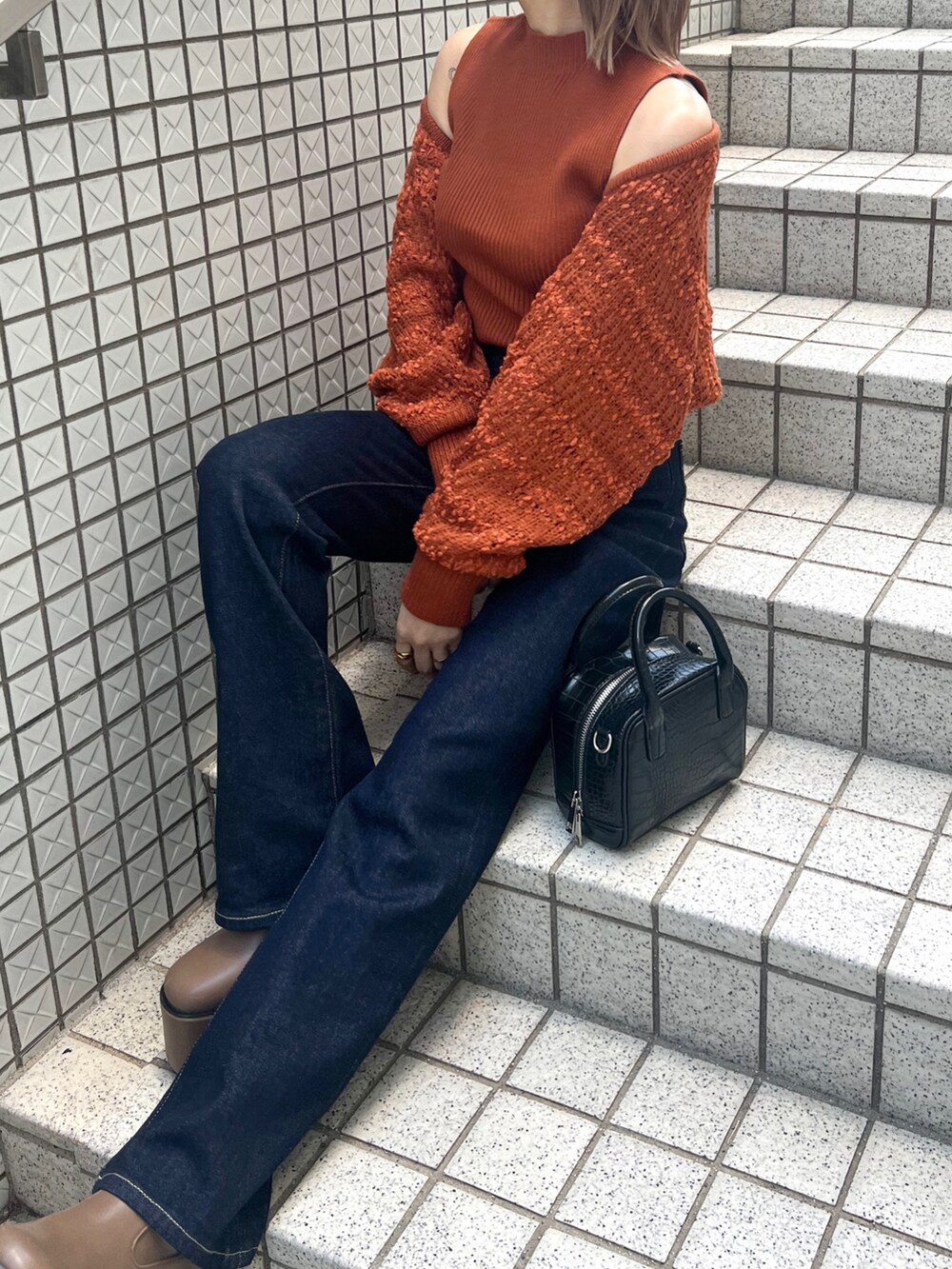 オレンジ系のカーディガン/ボレロ、ブルー系のデニムパンツ、ブラウン系のブーツを着用したレディースの夏コーディネートの4枚目の写真