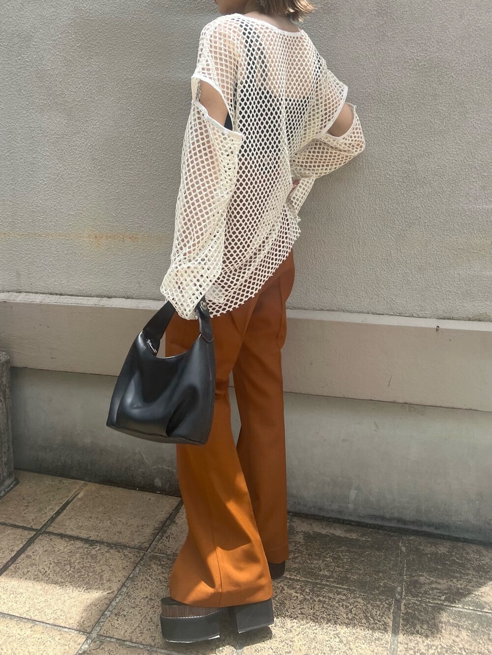 オレンジ系のその他パンツ、ブラック系のサンダル、ブラック系のハンドバッグを着用したレディースの夏コーディネートの6枚目の写真