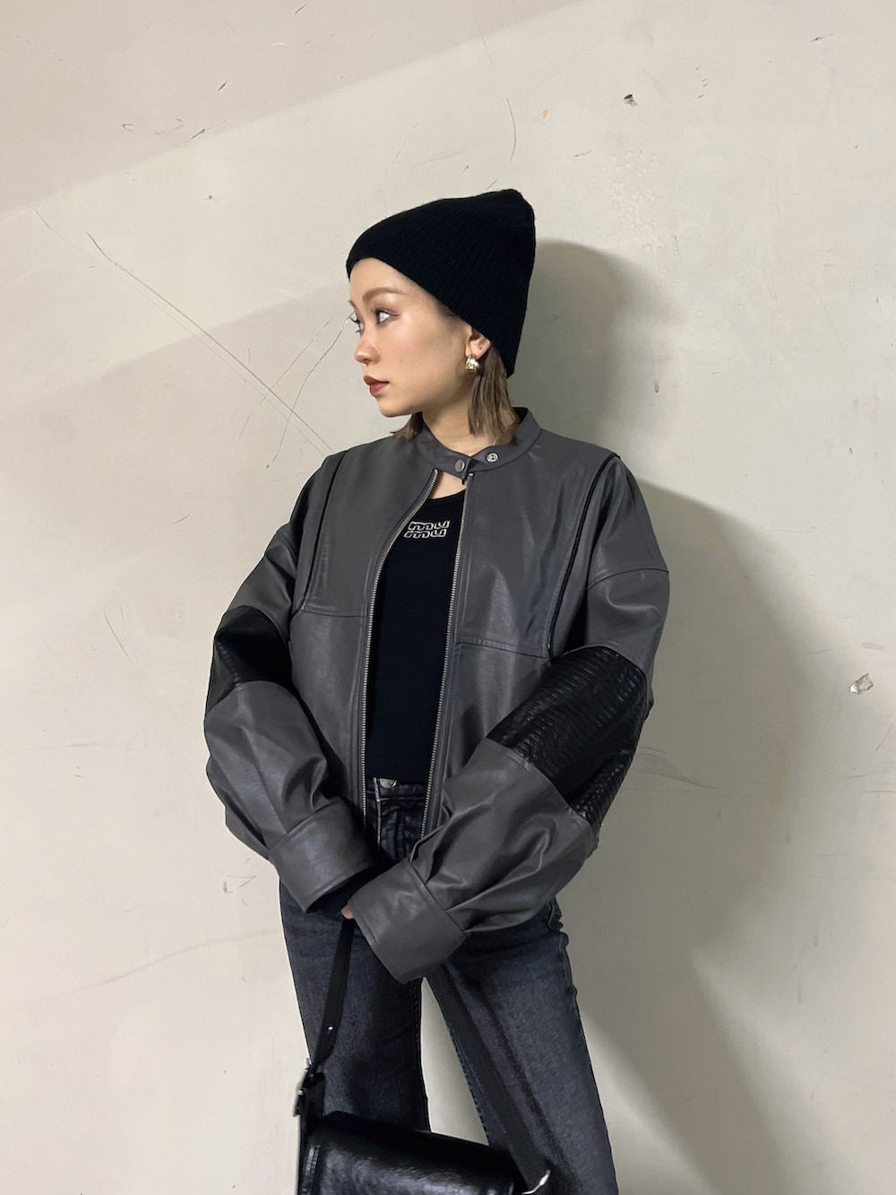 グレー系のブルゾン、ブラック系のTシャツ/カットソー、ブラック系のショルダーバッグを着用したレディースの冬コーディネートの5枚目の写真