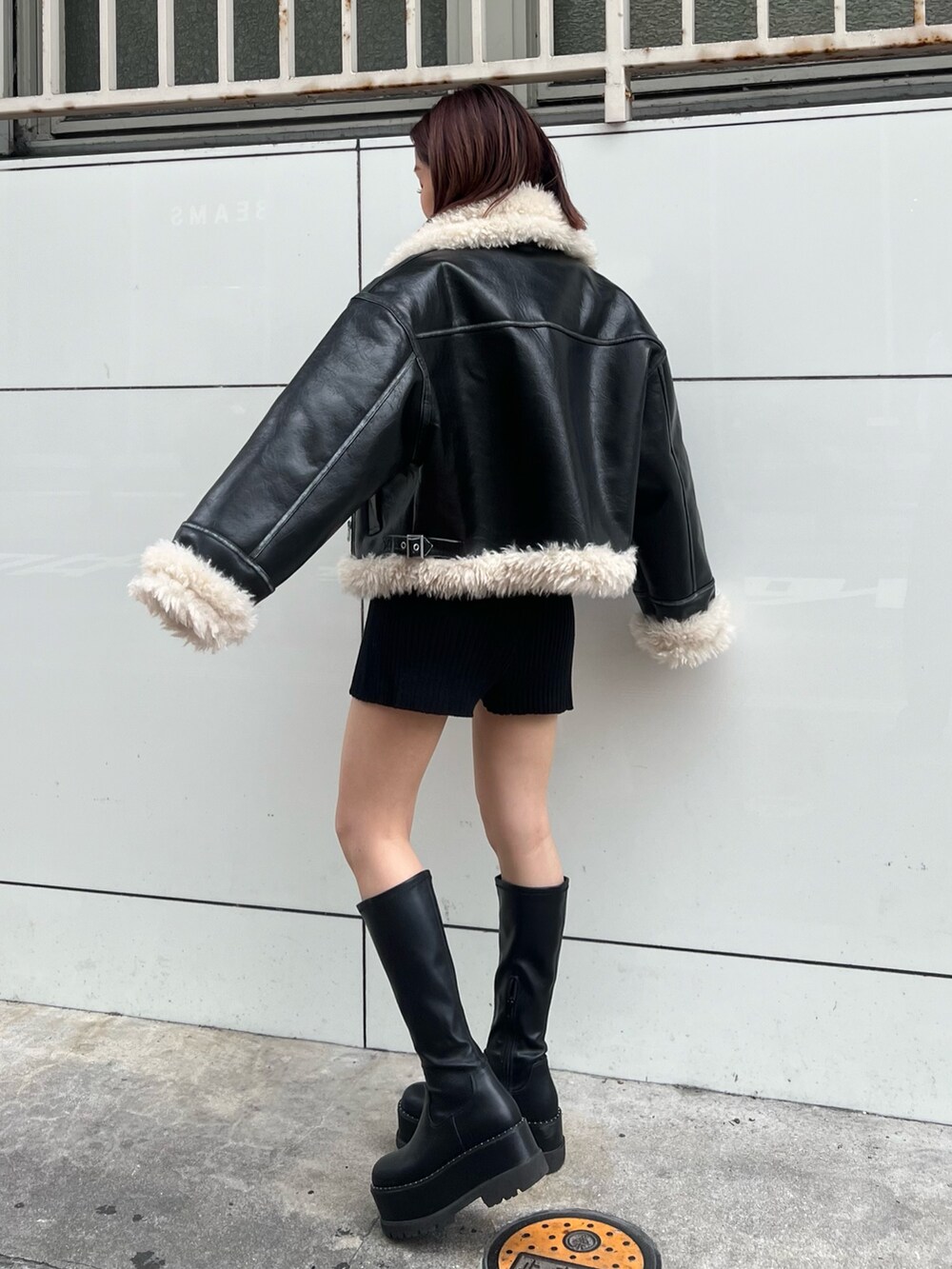 ブラック系のムートンコート、ブラック系のニット/セーター、ブラック系のその他パンツを着用したレディースの秋コーディネートの3枚目の写真