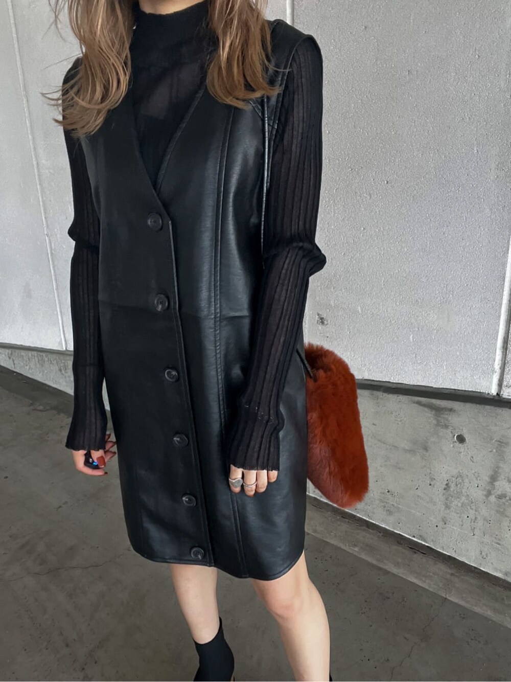 ブラック系のニット/セーター、ブラウン系のショルダーバッグ、ブラック系のワンピースを着用したレディースの秋コーディネートの7枚目の写真