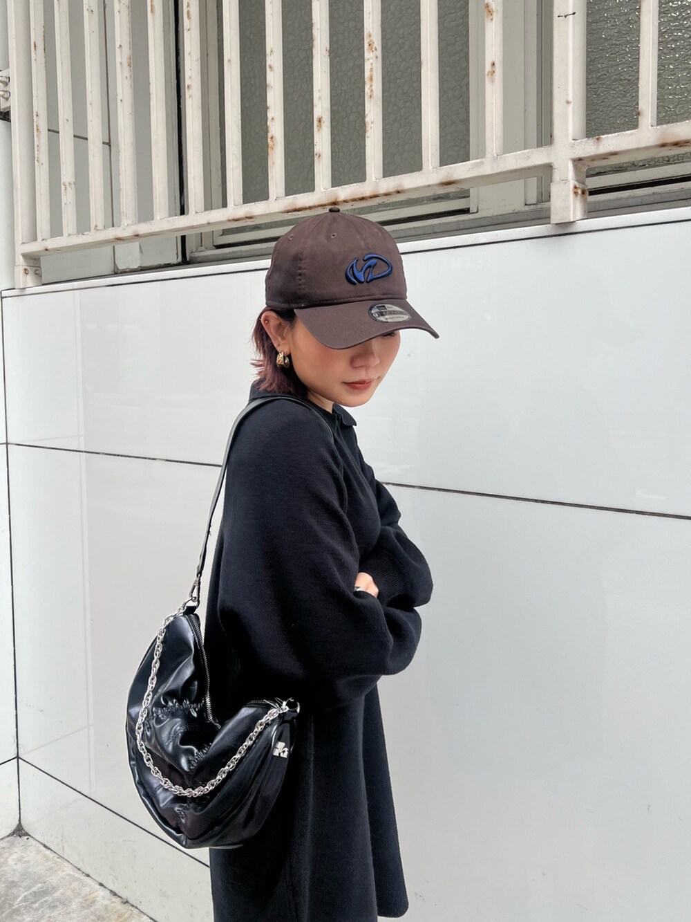 ブラック系のショルダーバッグ、ブラック系のブーツ、ブラック系のワンピースを着用したレディースの冬コーディネートの4枚目の写真