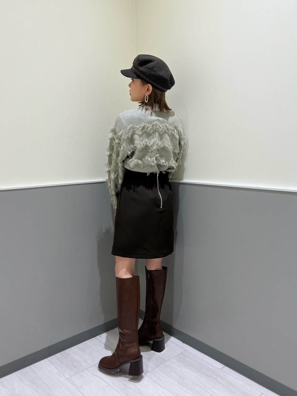 ベージュ系のニット/セーター、ブラウン系のスカート、ブラウン系のブーツを着用したレディースの秋コーディネートの4枚目の写真