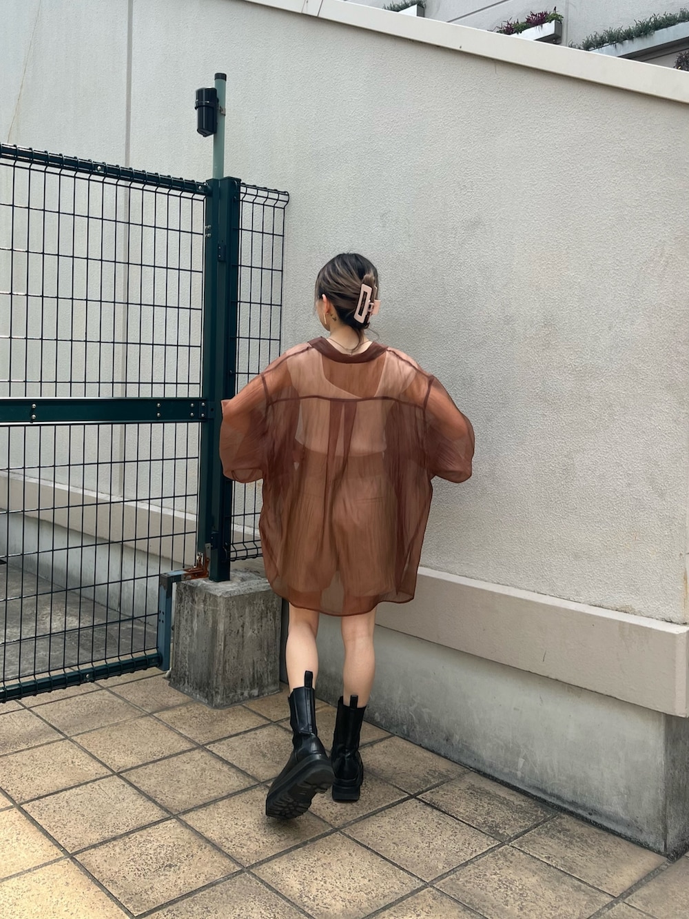 ベージュ系のスラックス、ブラウン系のシャツ/ブラウス、ホワイト系のタンクトップを着用したレディースの春コーディネートの2枚目の写真