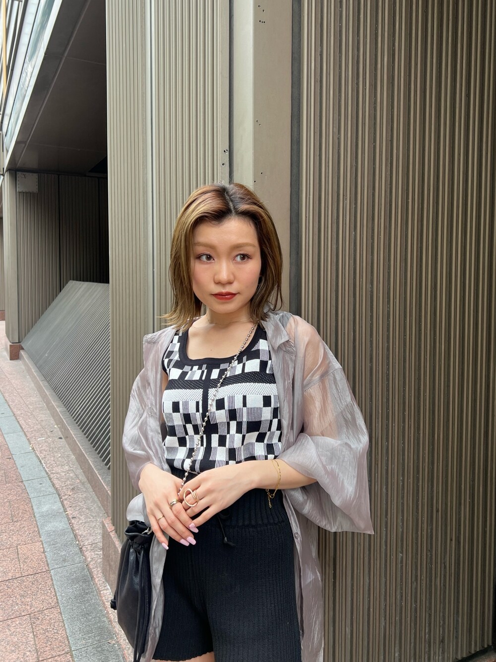 ブラック系のタンクトップ、ブラック系のその他パンツ、ブラック系のショルダーバッグを着用したレディースの春コーディネートの5枚目の写真