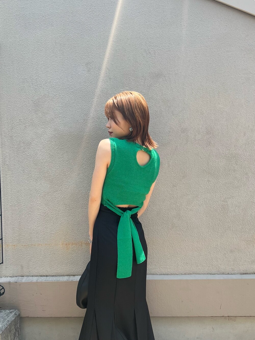 グリーン系のタンクトップ、ブラック系のスカート、その他のサンダルを着用したレディースの夏コーディネートの5枚目の写真