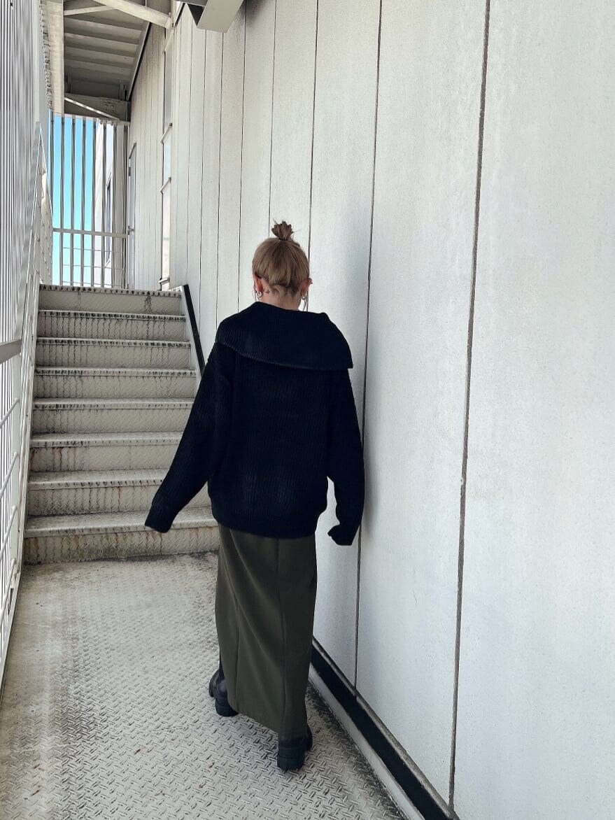 グリーン系のスカート、ブラック系のブーツ、ブラック系のニット/セーターを着用したレディースの秋コーディネートの2枚目の写真