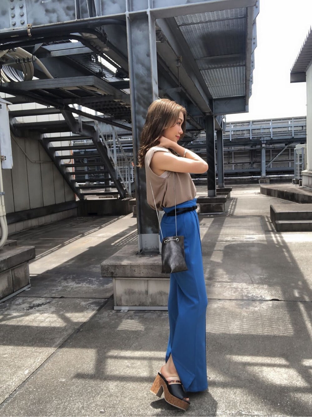 ブルー系のスラックス、ブラック系のサンダル、ベージュ系のタンクトップを着用したレディースの夏コーディネートの4枚目の写真