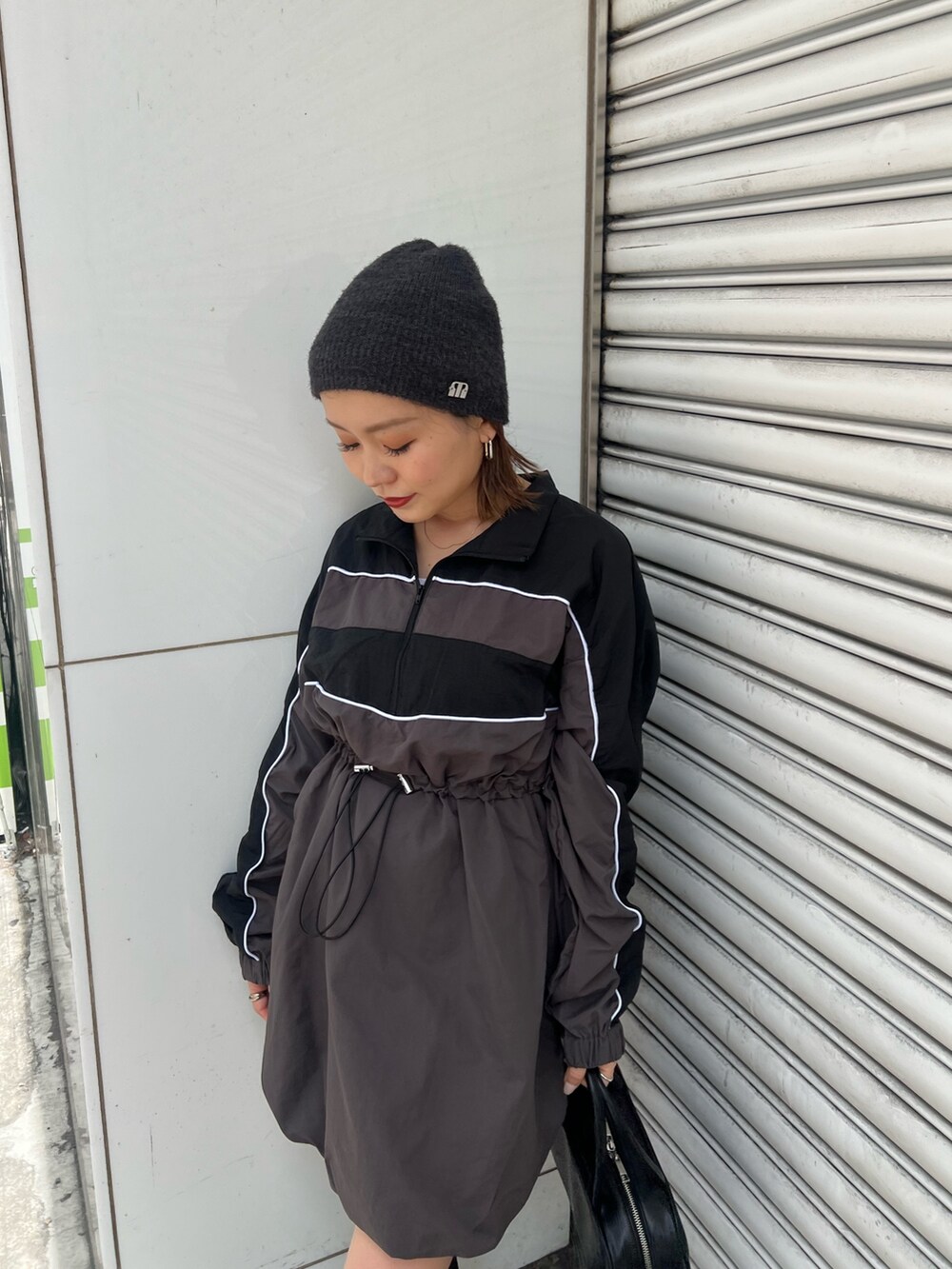 ブラック系のボストンバッグ、ブラック系のワンピース、ブラック系のブーツを着用したレディースの夏コーディネートの5枚目の写真