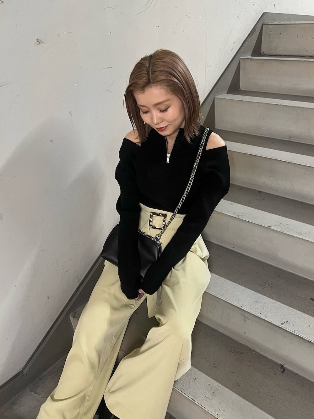 ブラック系のニット/セーター、ブラック系のハンドバッグ、ブラック系のブーツを着用したレディースの冬コーディネートの5枚目の写真