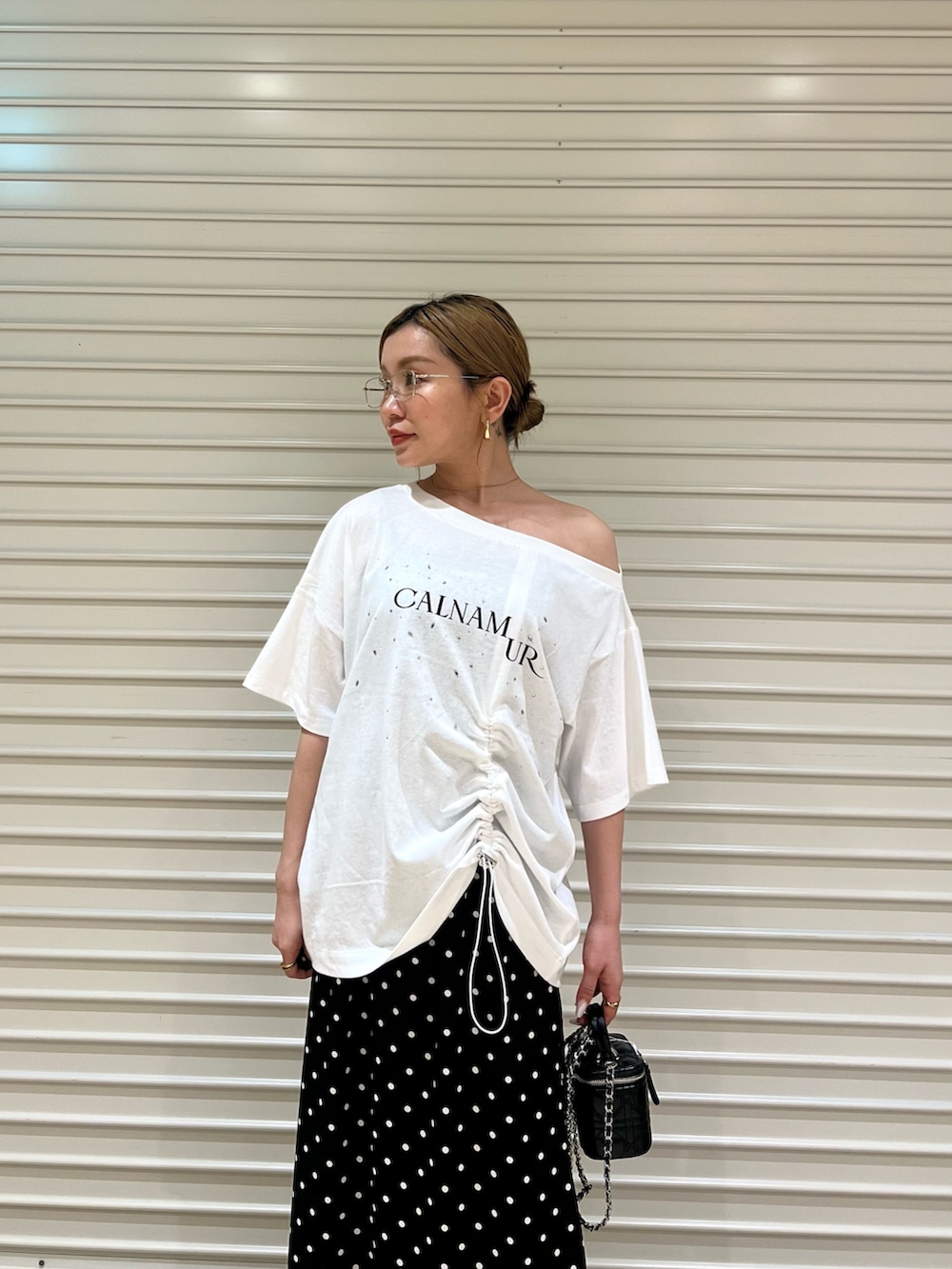 ホワイト系のTシャツ/カットソー、ブラック系のスカートを着用したレディースの夏コーディネートの4枚目の写真