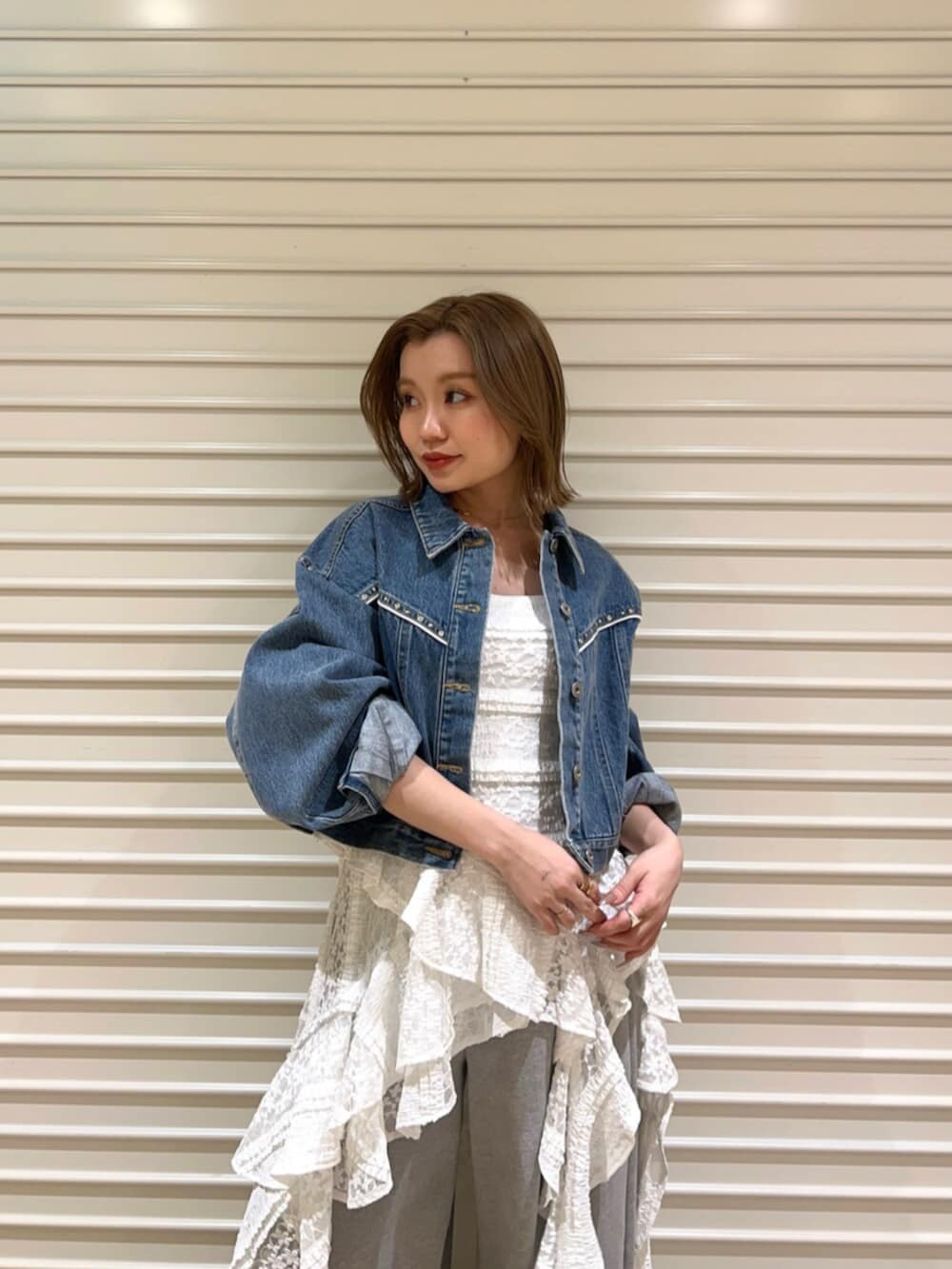 ブルー系のデニムジャケット、ホワイト系のワンピース、グレー系のその他パンツを着用したレディースの春コーディネートの4枚目の写真