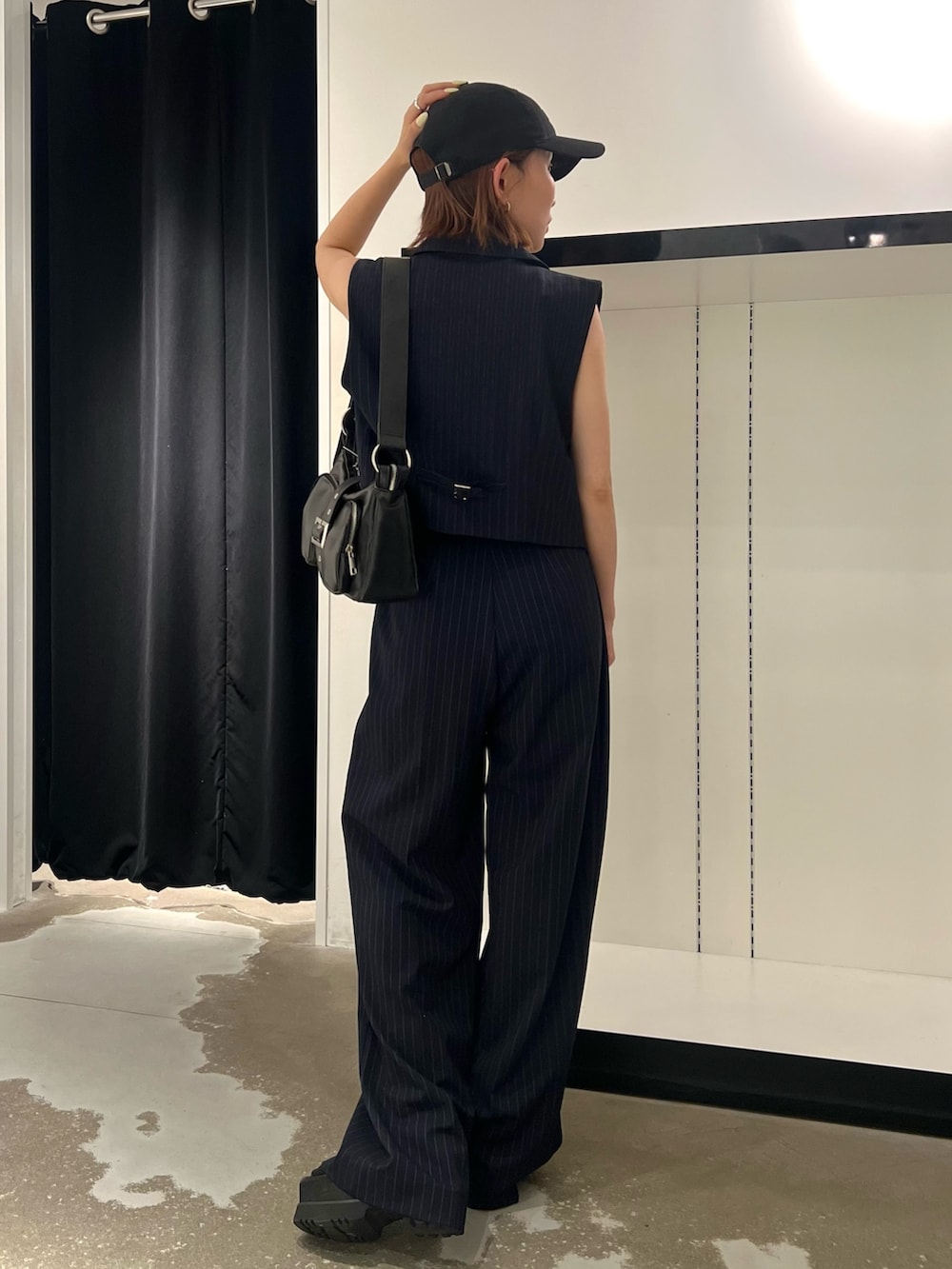 ブルー系のベスト、ブルー系のその他パンツ、ブラック系のキャミソールを着用したレディースの夏コーディネートの2枚目の写真