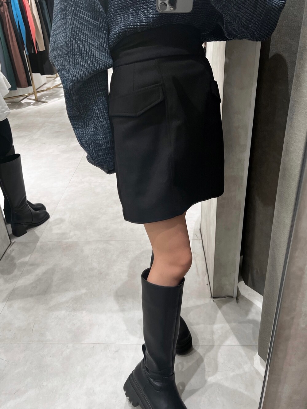 ブラック系のスカート、ブルー系のニット/セーター、ブラック系のブーツを着用したレディースの秋コーディネートの8枚目の写真