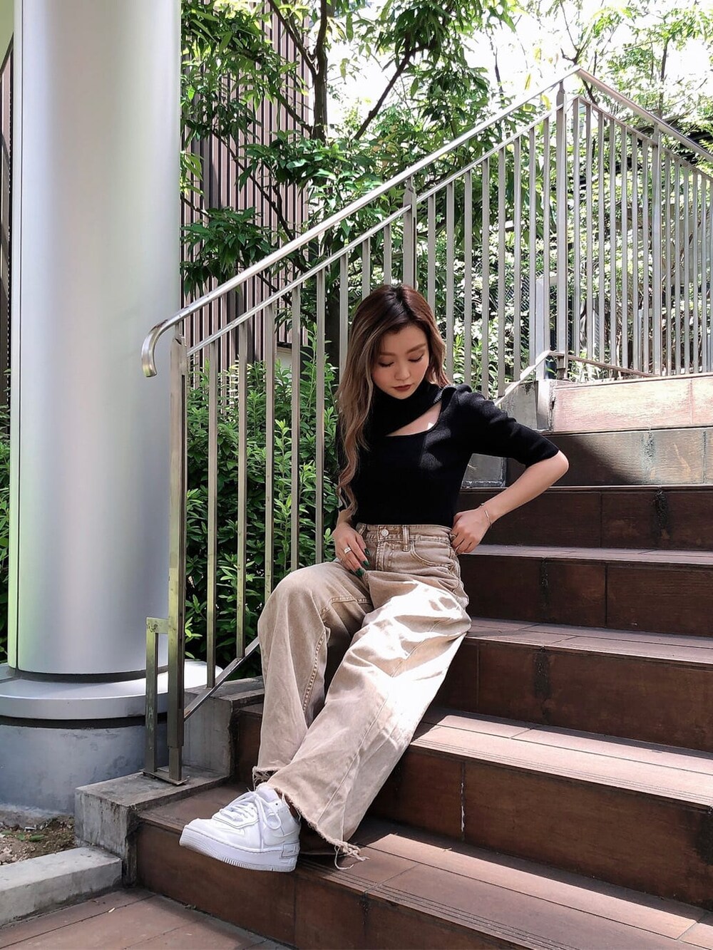 ブラック系のニット/セーター、ベージュ系のデニムパンツを着用したレディースの夏コーディネートの2枚目の写真