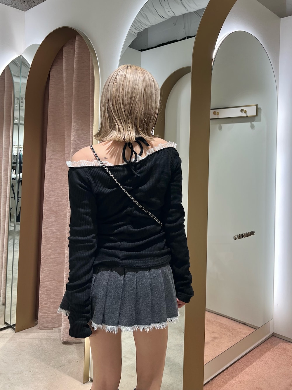 ブラック系のブーツ、ブラック系のスカートを着用したレディースの秋コーディネートの5枚目の写真