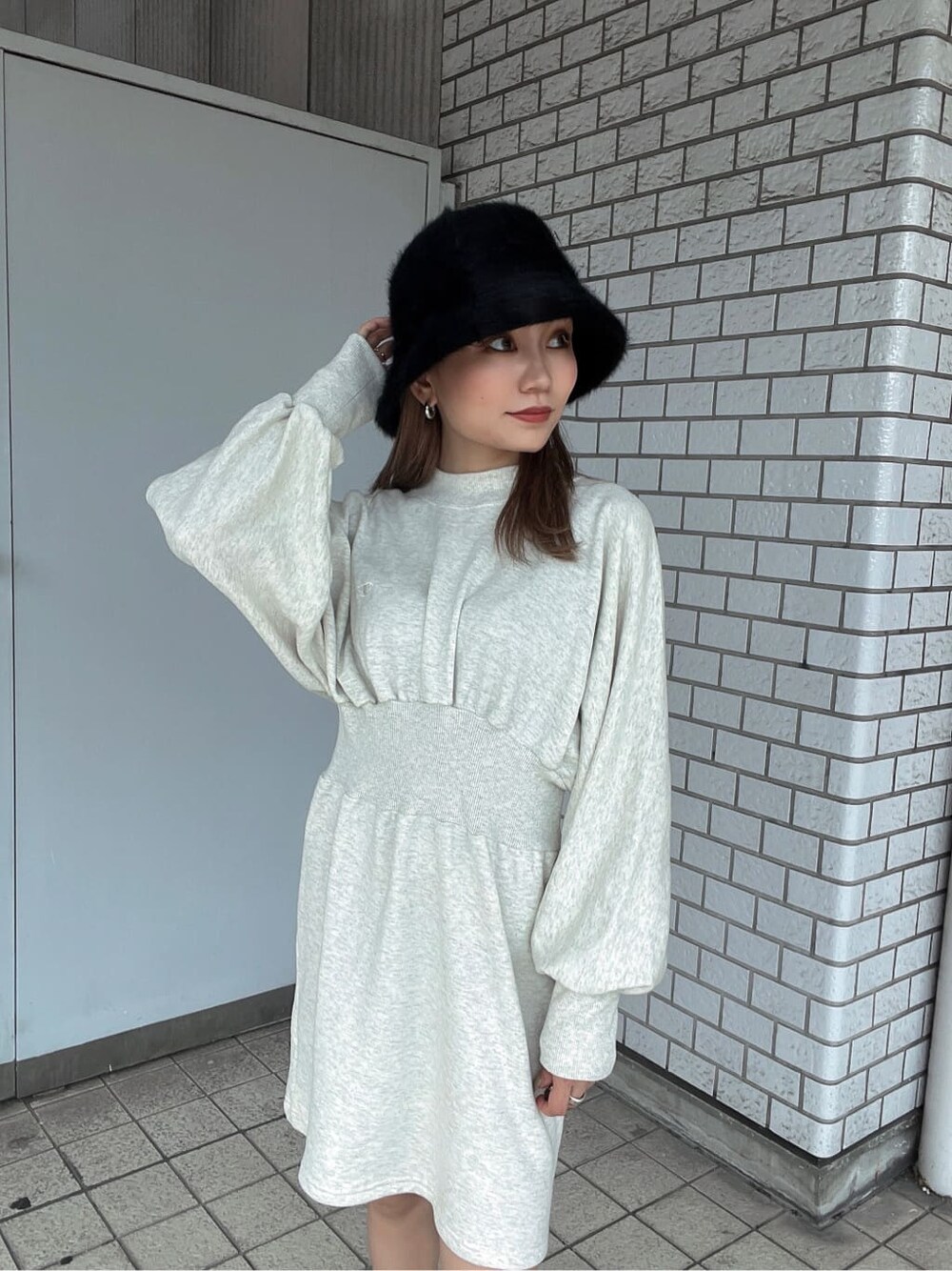 ホワイト系のワンピース、ブラック系のブーツ、ブラック系のブルゾンを着用したレディースの秋コーディネートの8枚目の写真