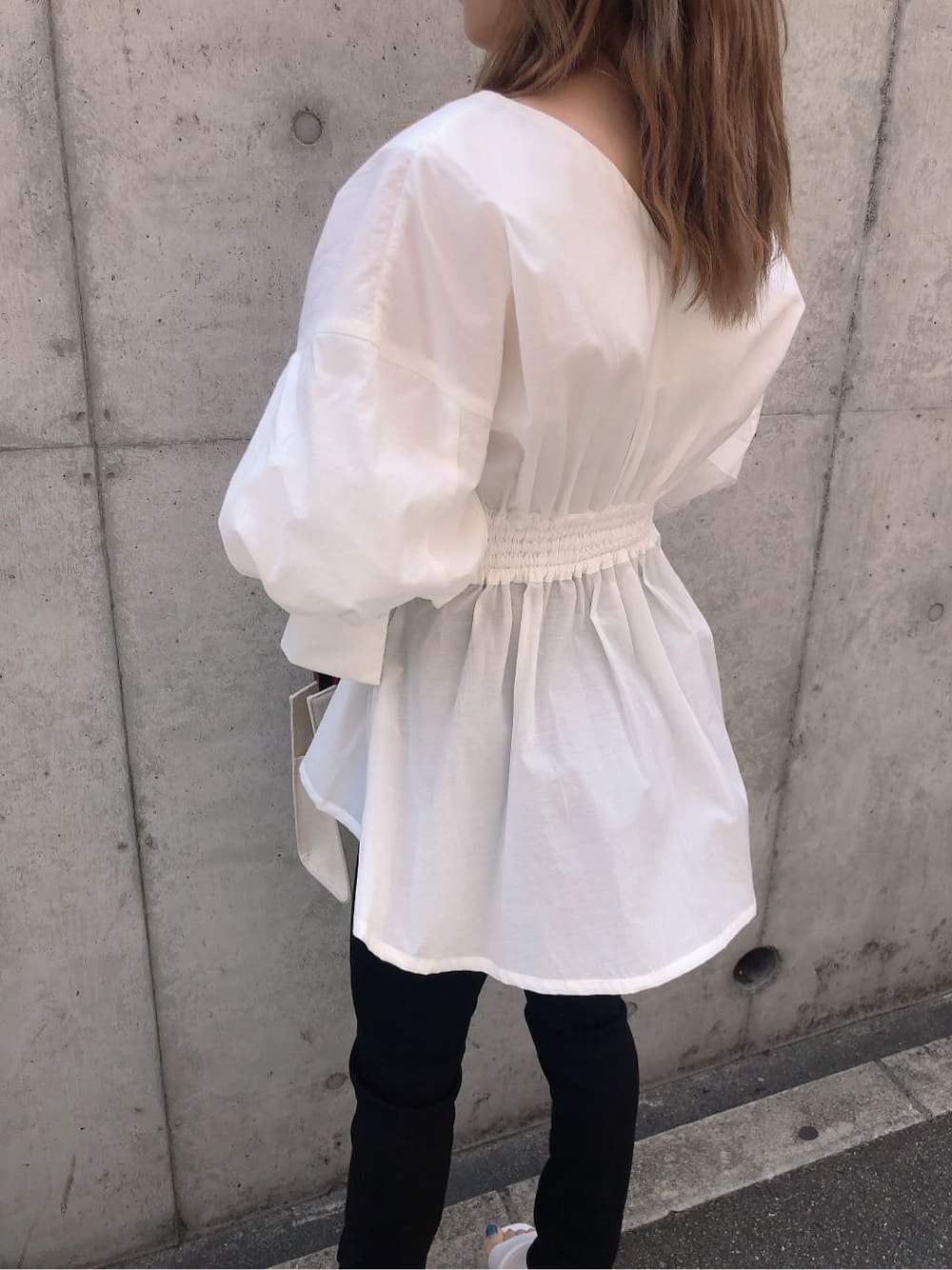 ホワイト系のサンダル、ブラック系のデニムパンツ、ホワイト系のハンドバッグを着用したレディースの春コーディネートの6枚目の写真