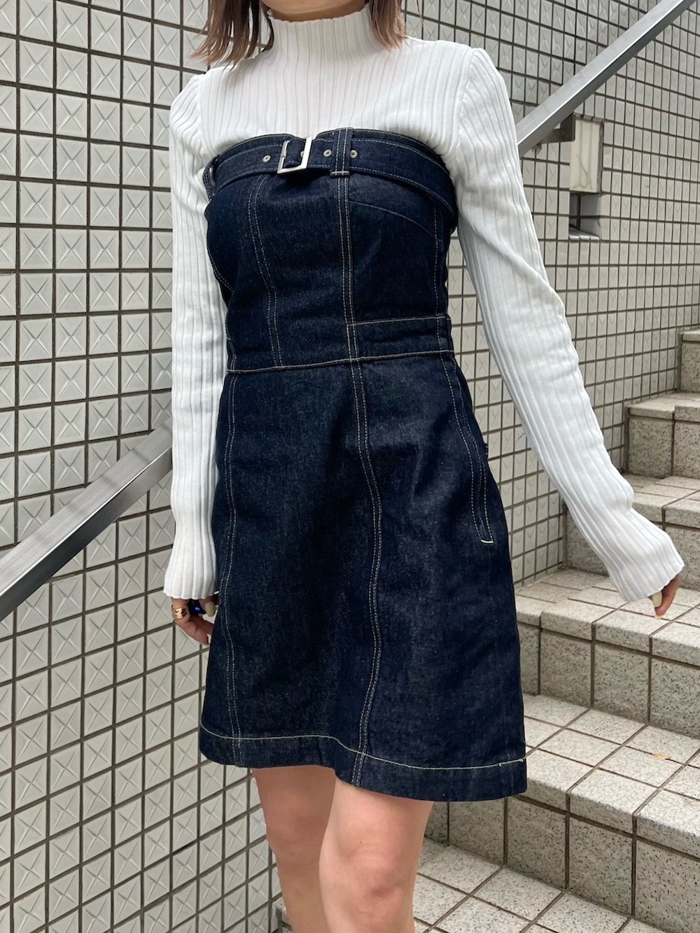 ホワイト系のニット/セーター、ブルー系のワンピース、ブラック系のブーツを着用したレディースの冬コーディネートの7枚目の写真