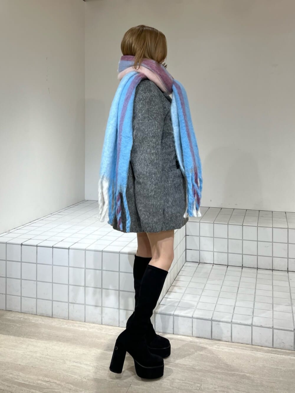 ブラック系のブーツ、グレー系のテーラードジャケット、その他のマフラーを着用したレディースの冬コーディネートの3枚目の写真