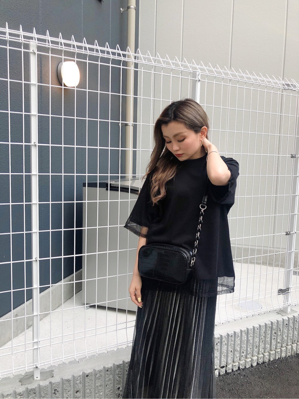 ブラック系のショルダーバッグ、ブラック系のスカート、ブラック系のTシャツ/カットソーを着用したレディースの春コーディネートの6枚目の写真