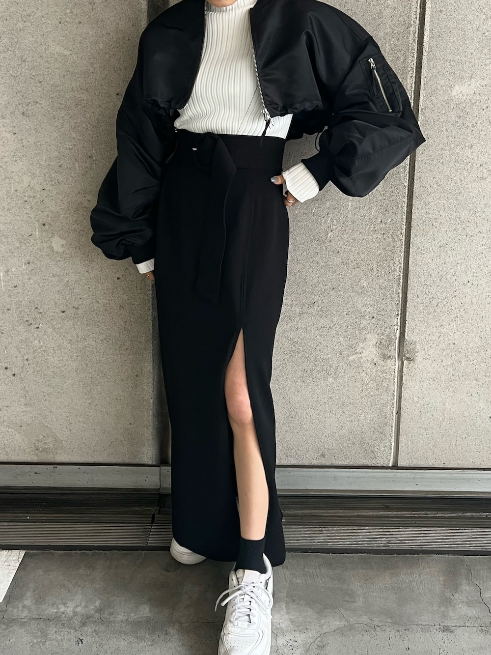 ブラック系のMA-1、ホワイト系のニット/セーター、ブラック系のスカートを着用したレディースの冬コーディネートの6枚目の写真