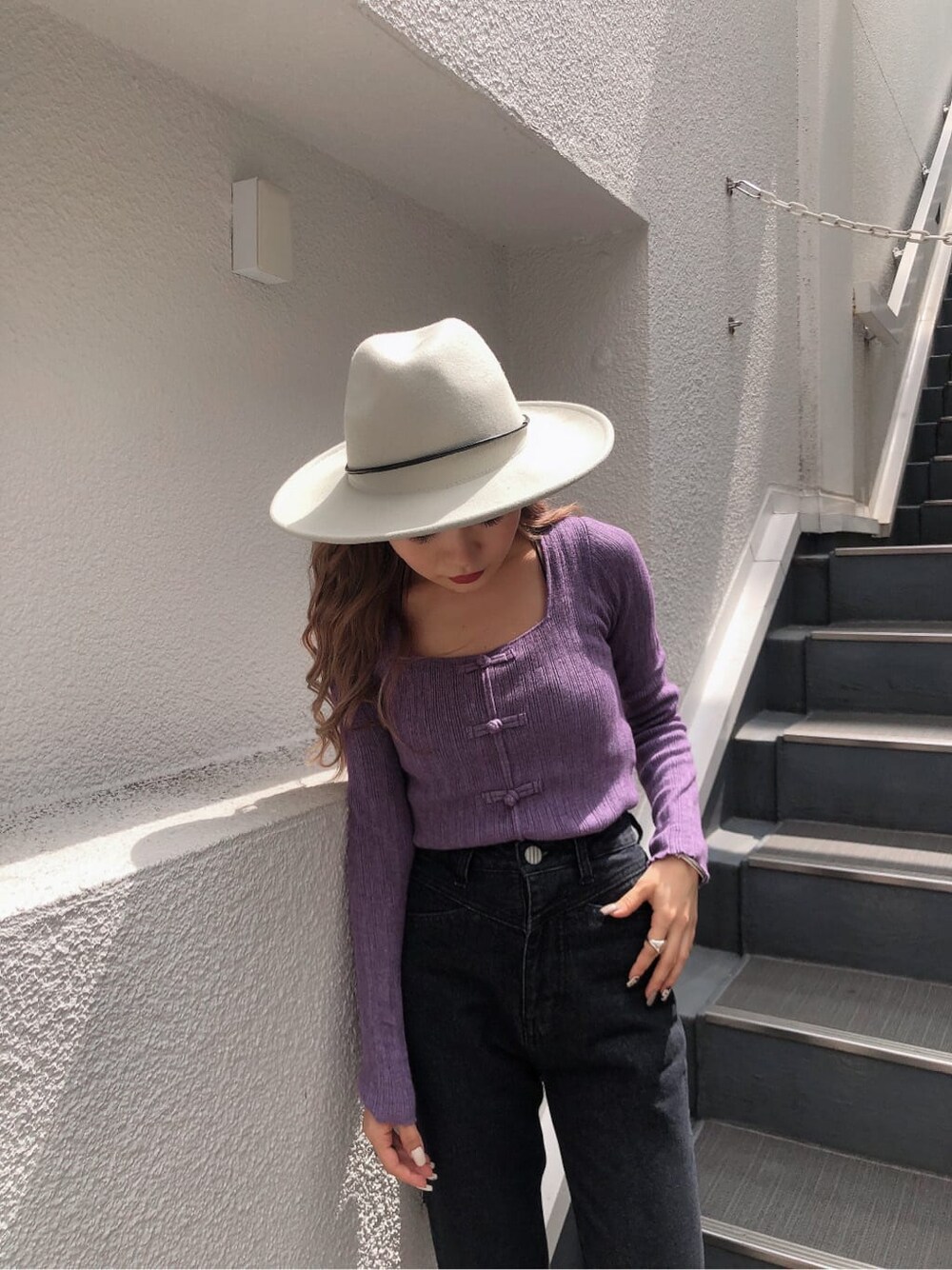 ホワイト系のブーツ、パープル系のニット/セーター、ブラック系のデニムパンツを着用したレディースの秋コーディネートの3枚目の写真