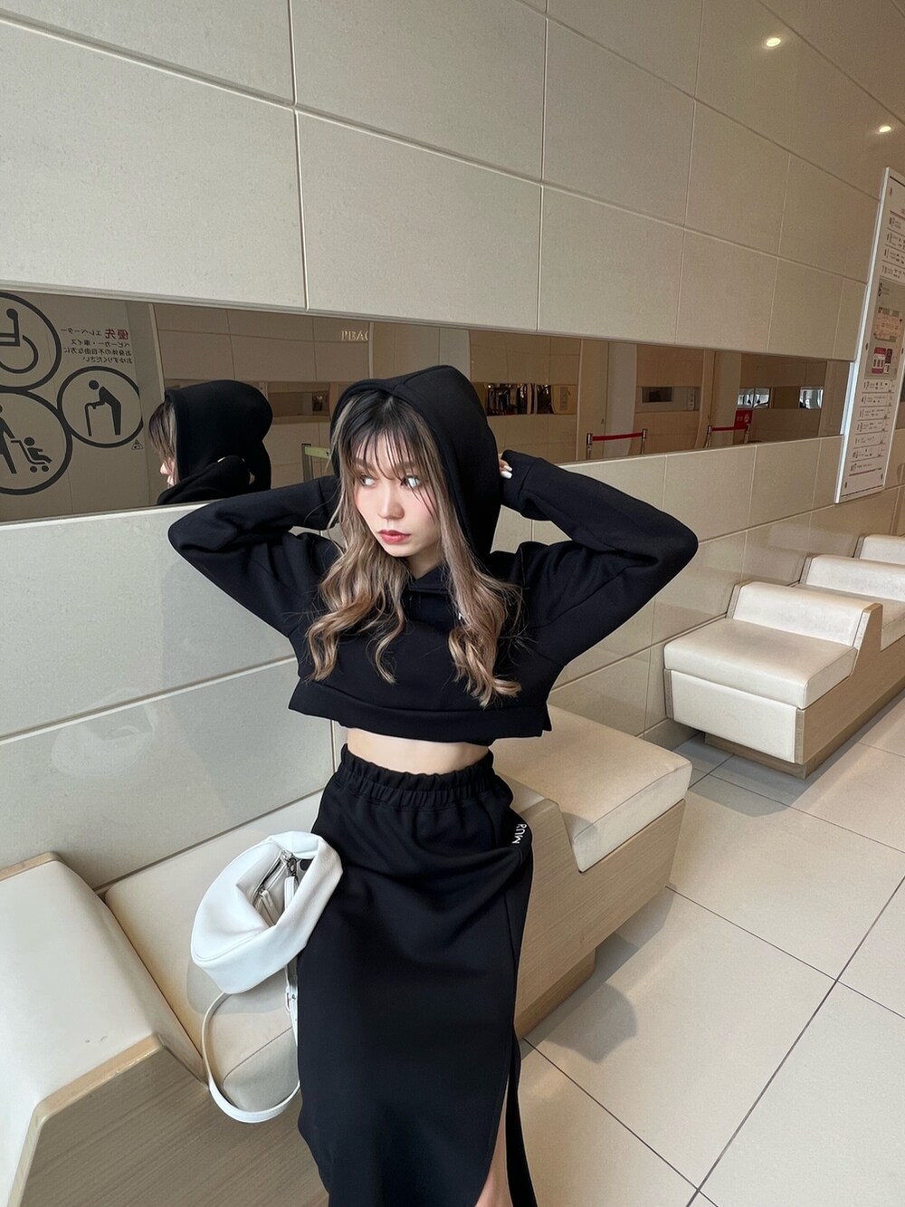 ブラック系のTシャツ/カットソー、ホワイト系のハンドバッグ、ブラック系のスカートを着用したレディースの春コーディネートの5枚目の写真