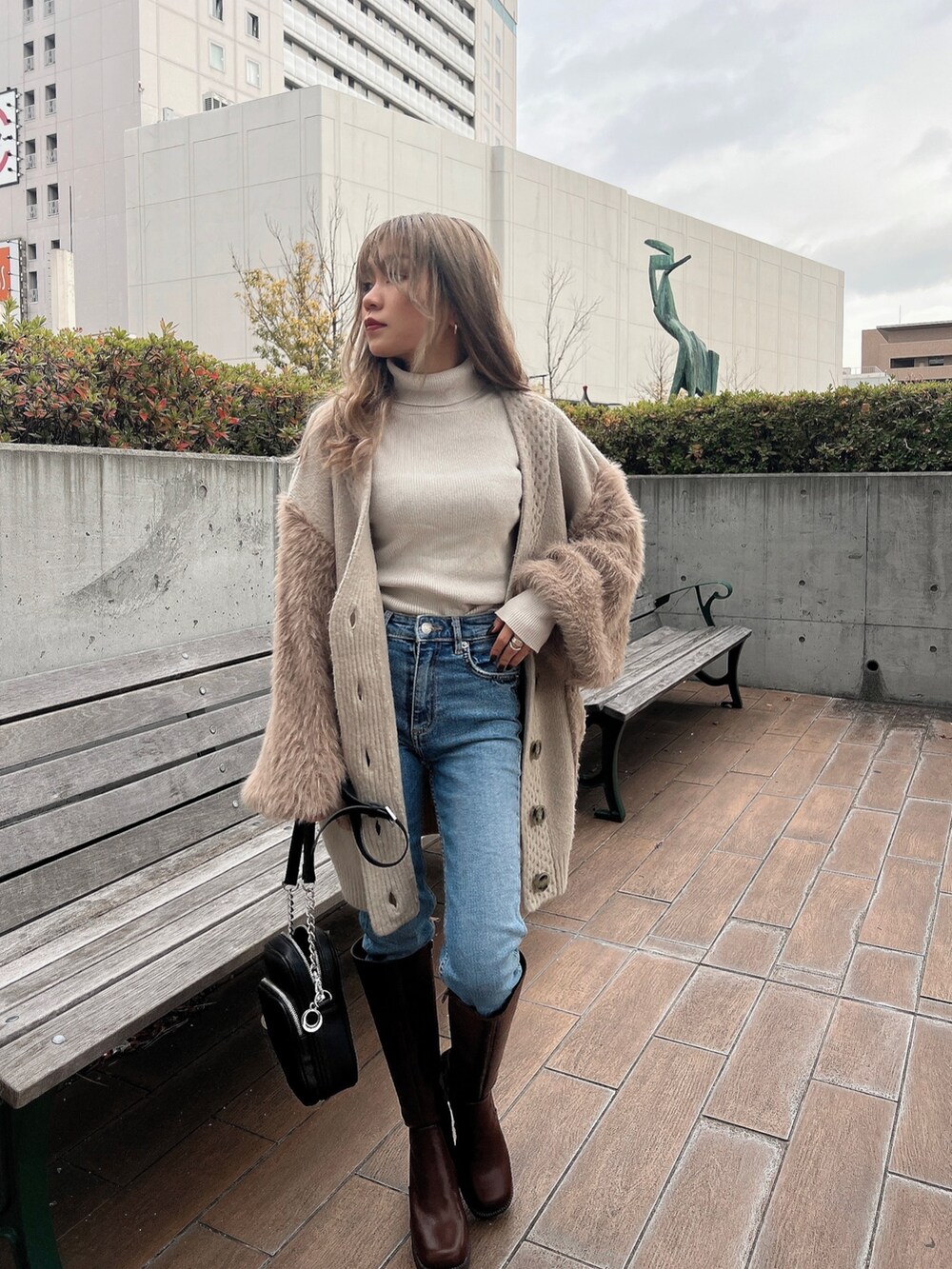 ホワイト系のニット/セーター、ベージュ系のカーディガン/ボレロ、ブラウン系のブーツを着用したレディースの冬コーディネートの5枚目の写真