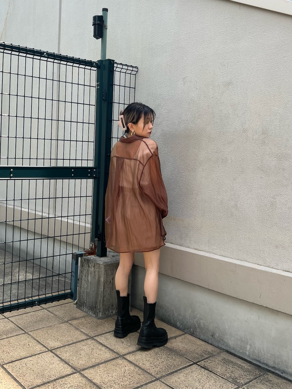 ベージュ系のスラックス、ブラウン系のシャツ/ブラウス、ホワイト系のタンクトップを着用したレディースの春コーディネートの3枚目の写真