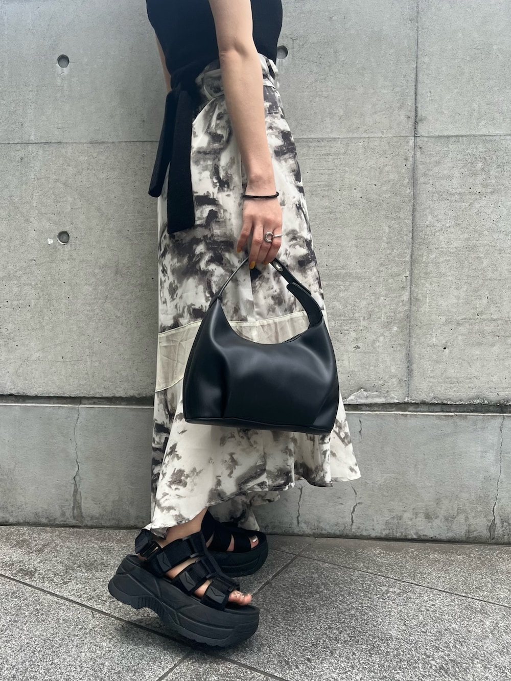 ブラック系のサンダル、ブラック系のハンドバッグ、その他のスカートを着用したレディースの夏コーディネートの7枚目の写真