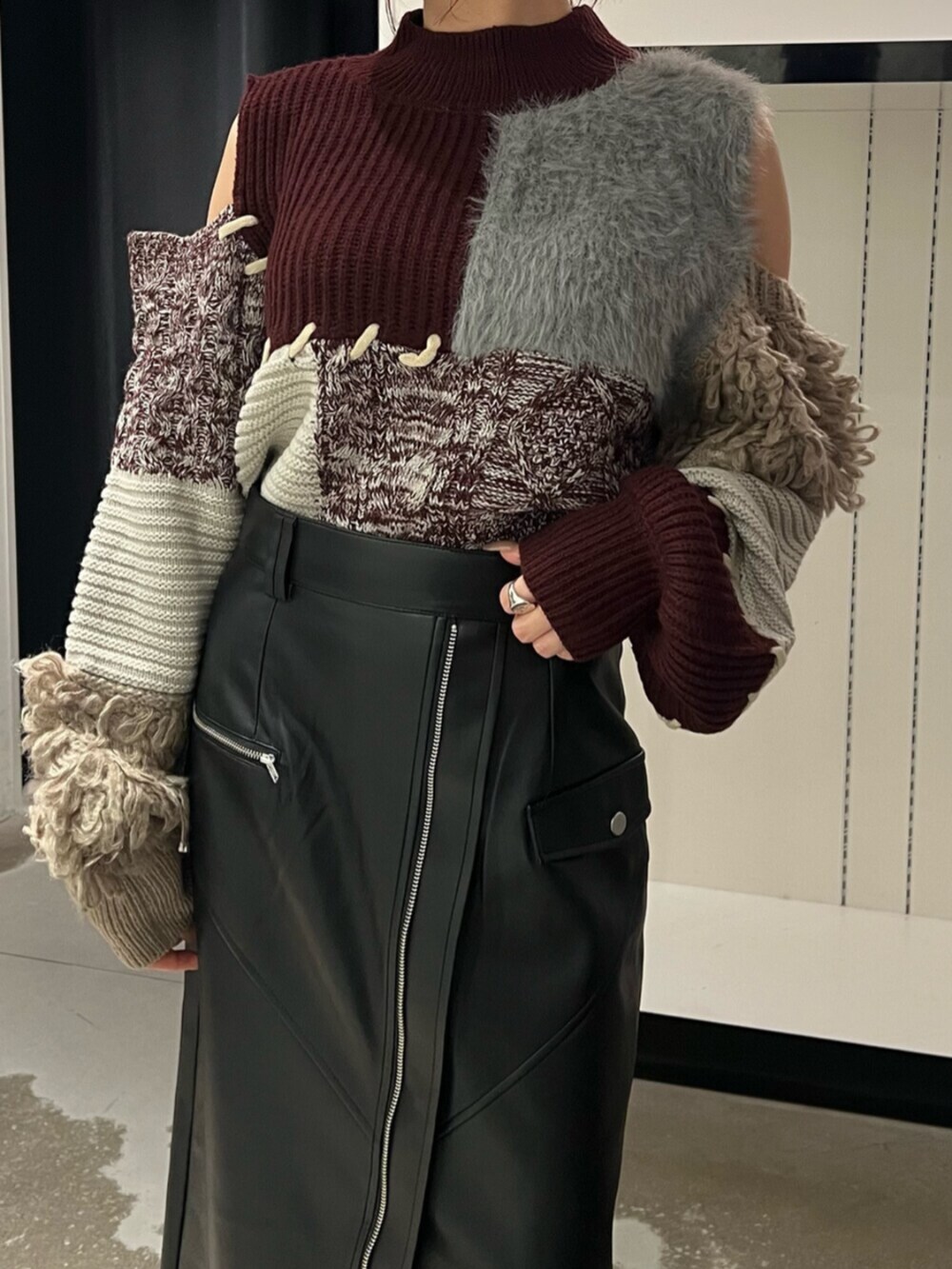 ブラック系のブーツ、レッド系のニット/セーター、ブラック系のスカートを着用したレディースの秋コーディネートの7枚目の写真