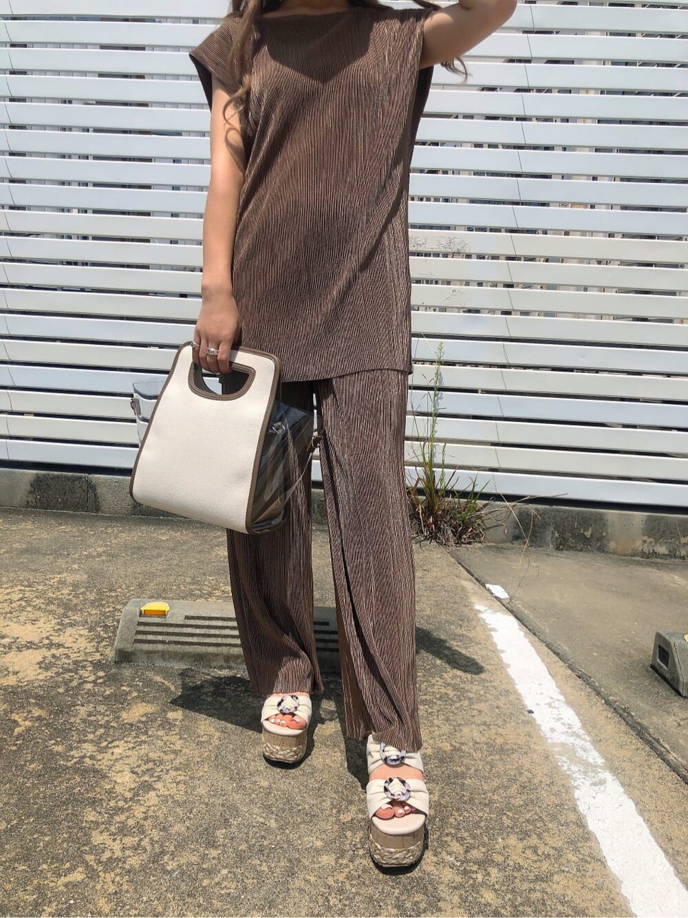 ベージュ系のシャツ/ブラウス、ブラウン系のハンドバッグ、ホワイト系のサンダルを着用したレディースの夏コーディネートの5枚目の写真