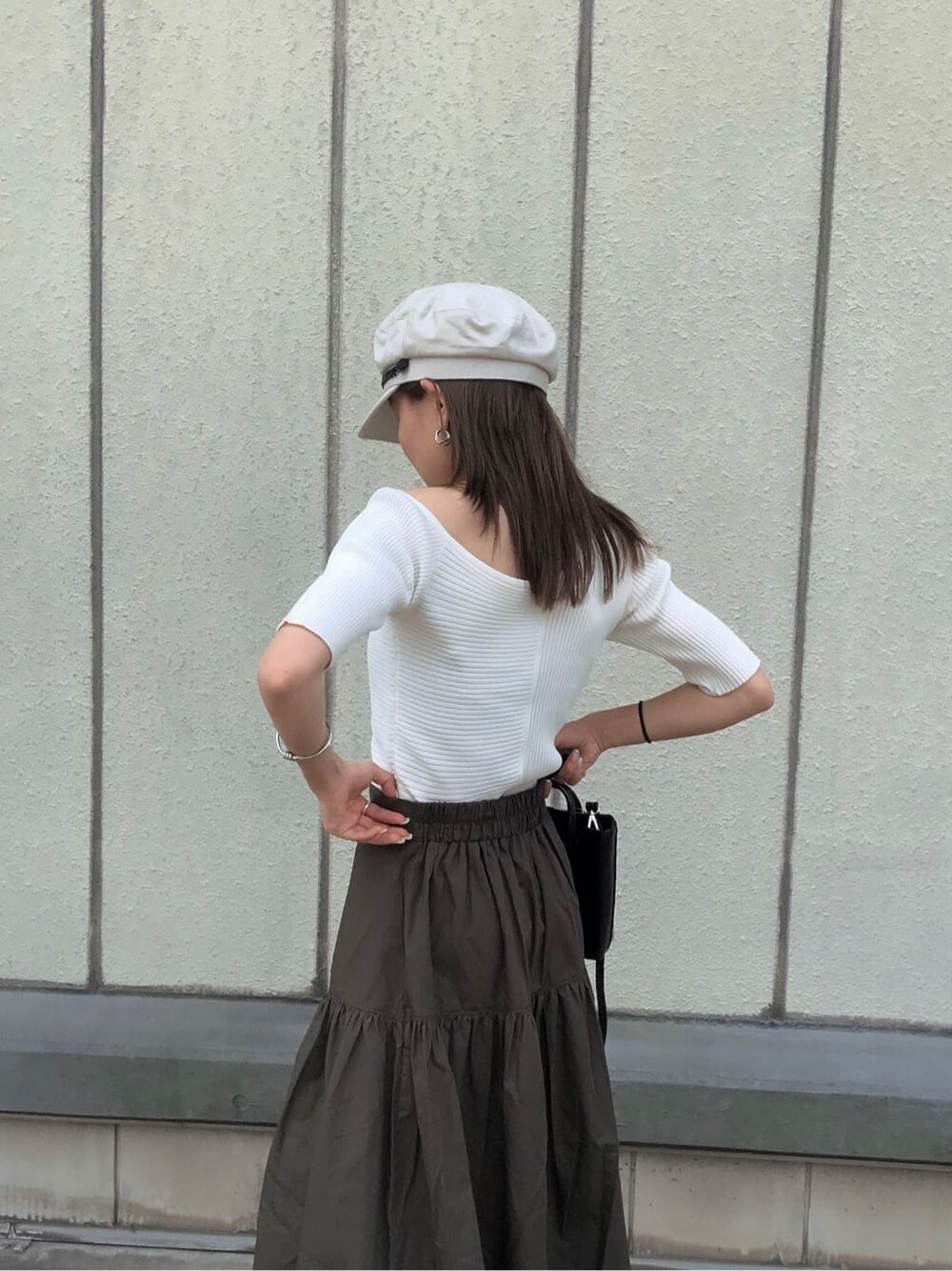 ブラック系のサンダル、ブラック系のショルダーバッグ、ホワイト系のニット/セーターを着用したレディースの夏コーディネートの6枚目の写真