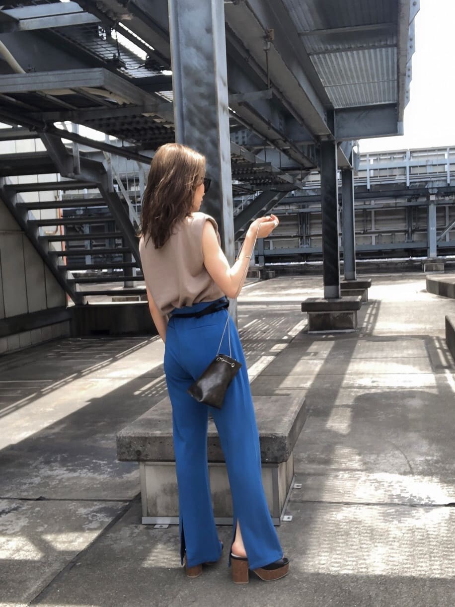 ブルー系のスラックス、ブラック系のサンダル、ベージュ系のタンクトップを着用したレディースの夏コーディネートの3枚目の写真