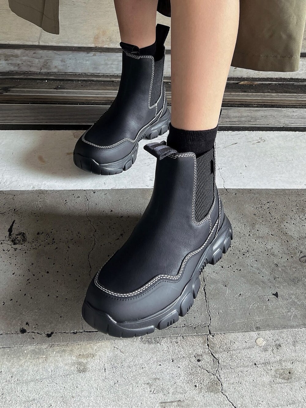グリーン系のその他アウター、ブラック系のスウェットパンツ、ブラック系のブーツを着用したレディースの秋コーディネートの8枚目の写真