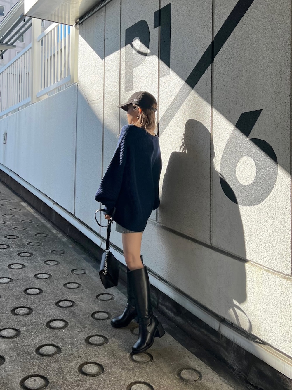 ブルー系のニット/セーター、グレー系のスウェットパンツ、ブラック系のブーツを着用したレディースの冬コーディネートの3枚目の写真