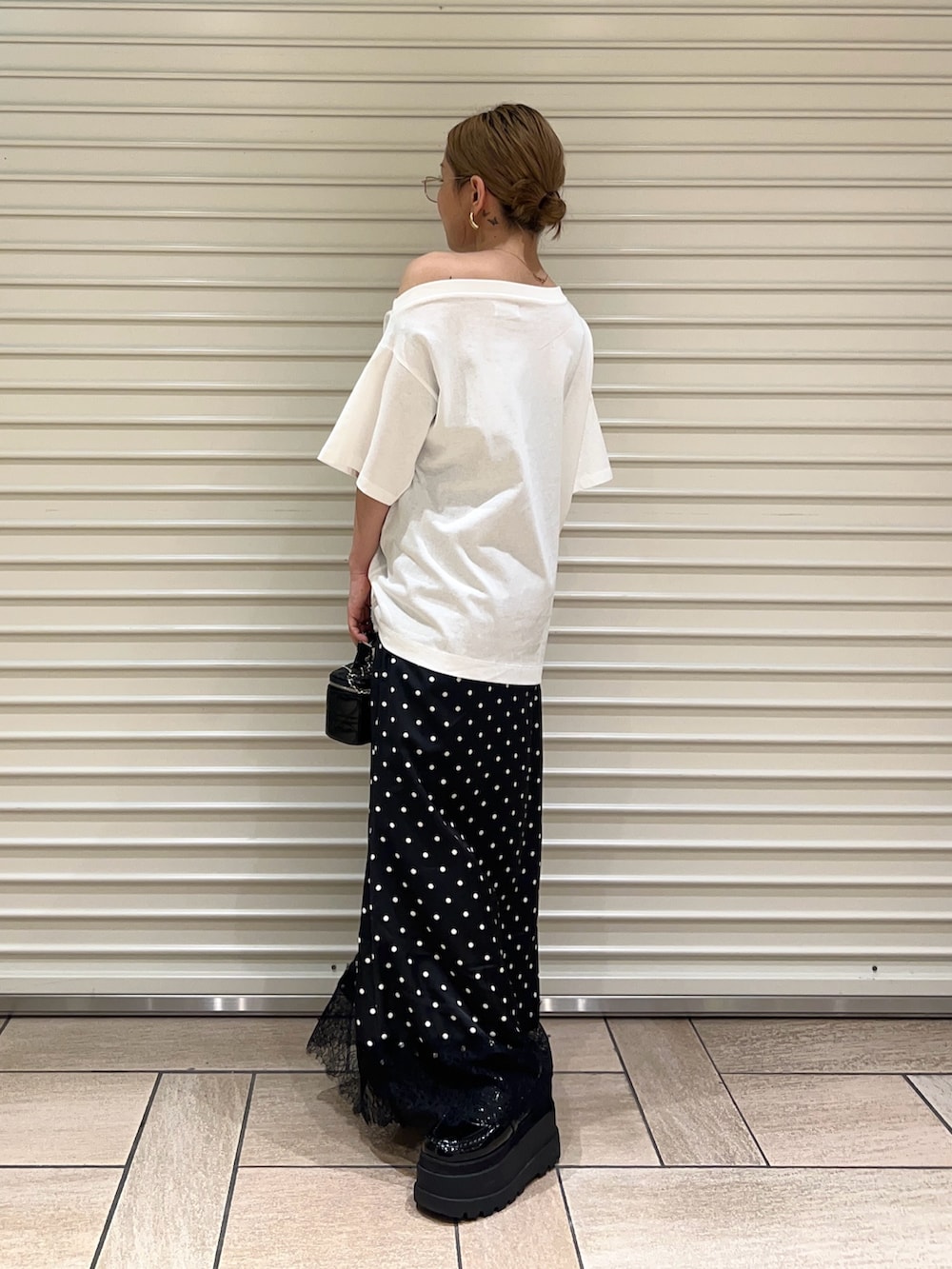 ホワイト系のTシャツ/カットソー、ブラック系のスカートを着用したレディースの夏コーディネートの2枚目の写真