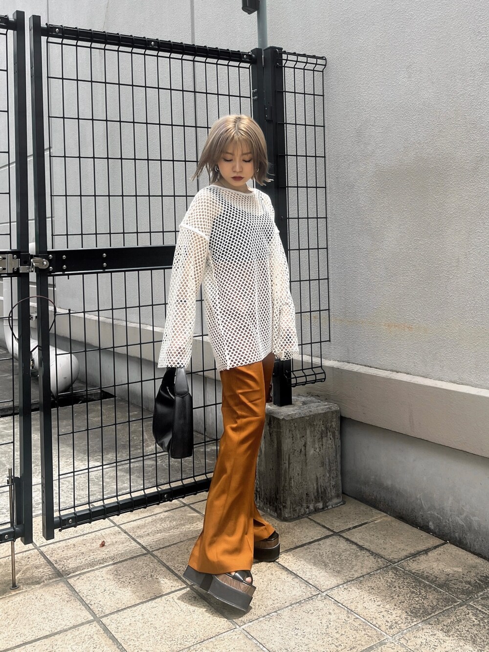 オレンジ系のその他パンツ、ブラック系のサンダル、ブラック系のハンドバッグを着用したレディースの夏コーディネートの2枚目の写真