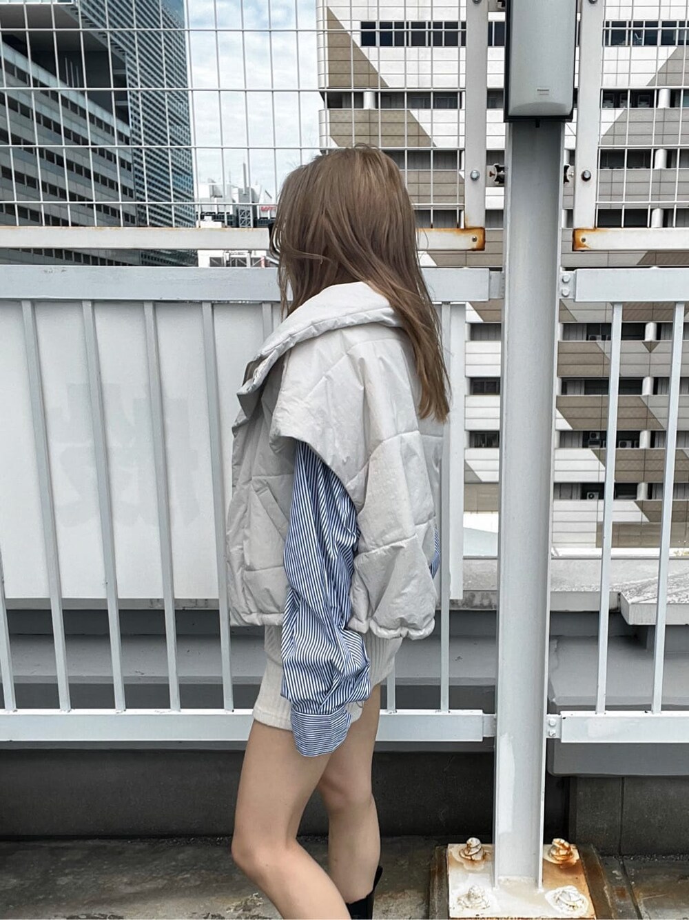 ブルー系のシャツ/ブラウス、ホワイト系のダウンベストを着用したレディースの秋コーディネートの7枚目の写真