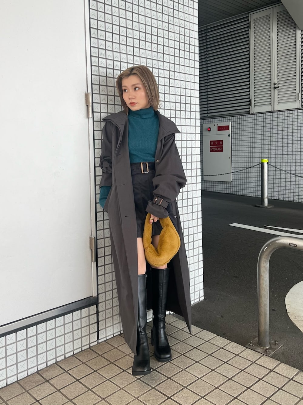 グレー系のトレンチコート、ブルー系のニット/セーター、ブラック系のその他パンツを着用したレディースの秋コーディネートの3枚目の写真