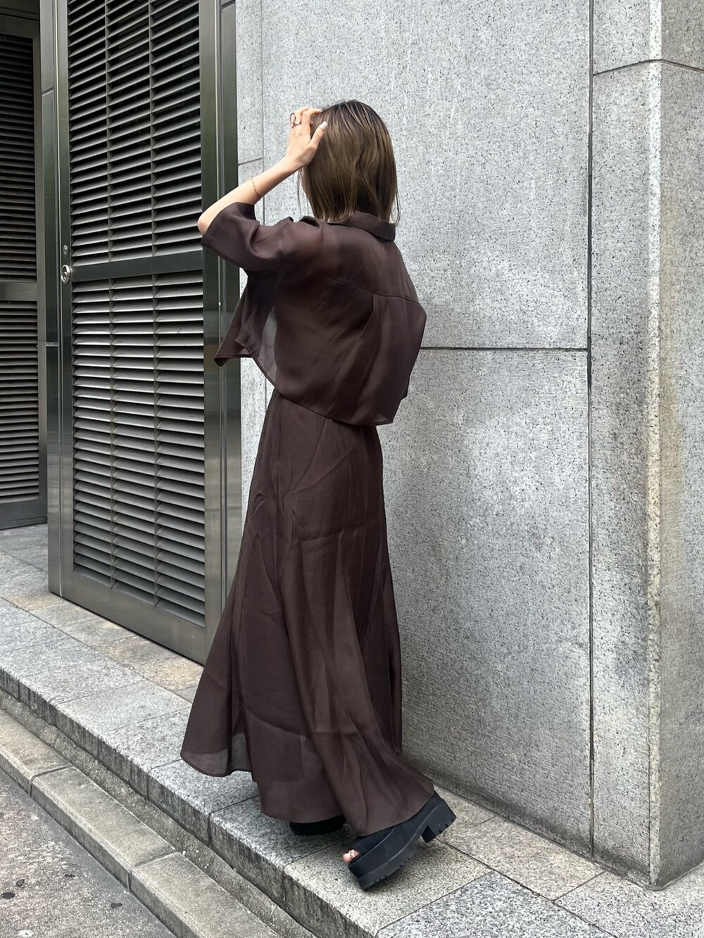 ブラック系のブーツ、その他のニット/セーター、ブラウン系のスカートを着用したレディースの夏コーディネートの2枚目の写真