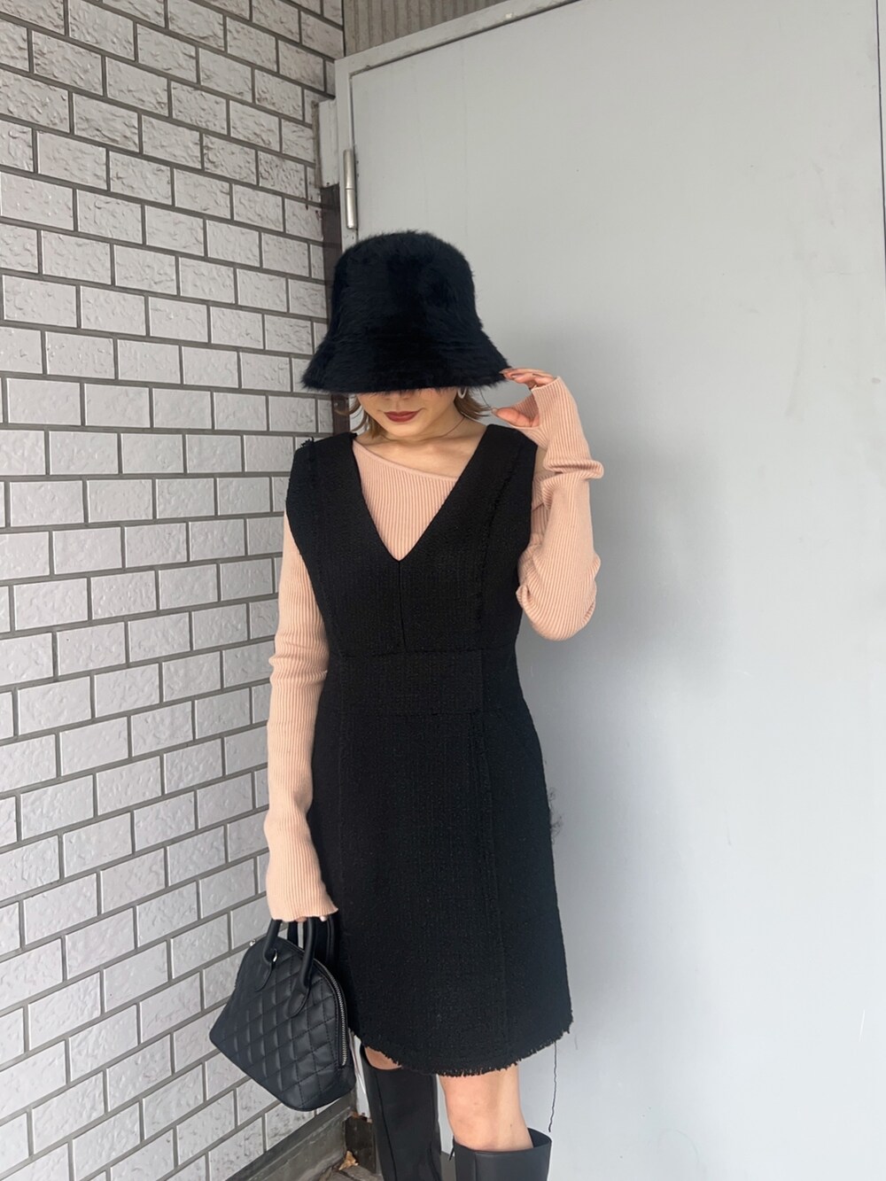 ベージュ系のニット/セーター、ブラック系のワンピース、ブラック系のブーツを着用したレディースの冬コーディネートの5枚目の写真