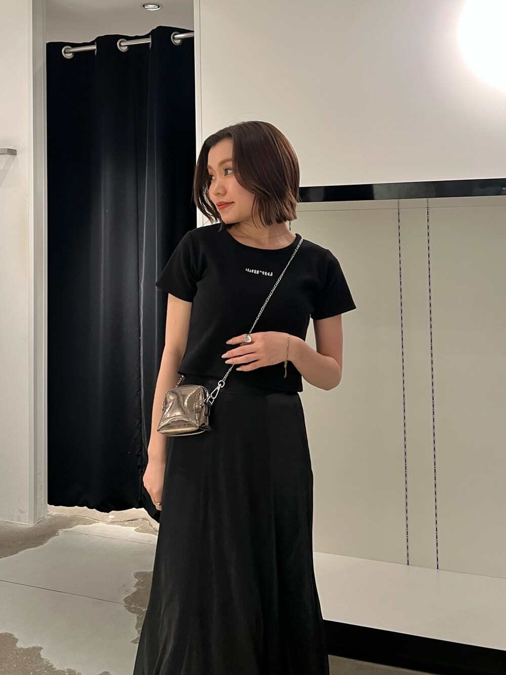 ブラック系のTシャツ/カットソー、ブラック系のスカート、ゴールド系のショルダーバッグを着用したレディースの夏コーディネートの5枚目の写真