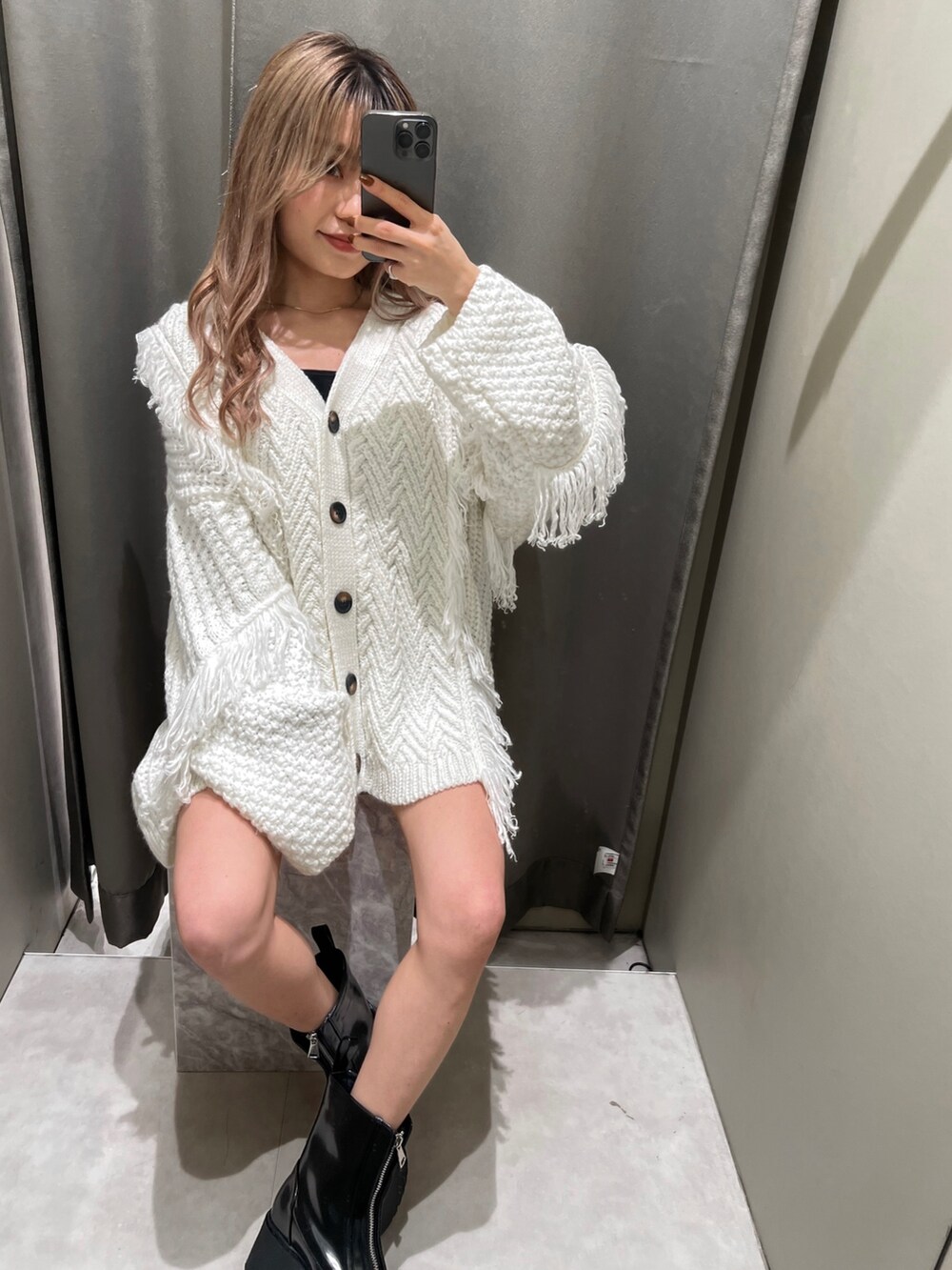 ホワイト系のカーディガン/ボレロ、ブラック系のスウェットパンツ、ブラック系のブーツを着用したレディースの冬コーディネートの2枚目の写真