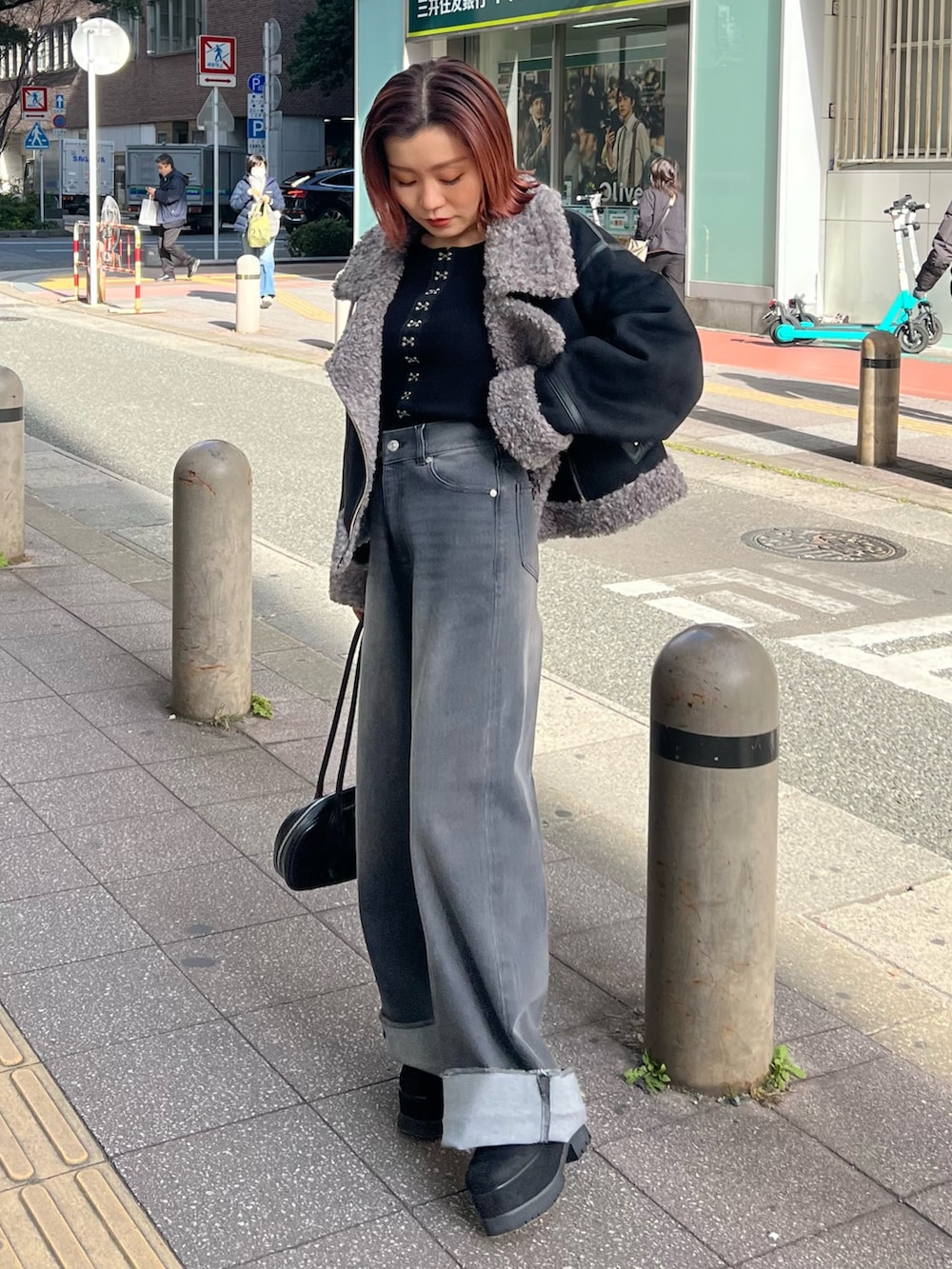 グレー系のデニムパンツ、ブラック系のニット/セーター、ブラック系のブーツを着用したレディースの冬コーディネートの3枚目の写真