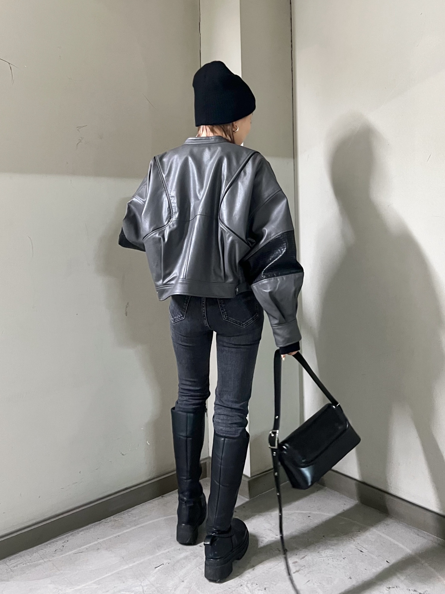 グレー系のブルゾン、ブラック系のTシャツ/カットソー、ブラック系のショルダーバッグを着用したレディースの冬コーディネートの3枚目の写真